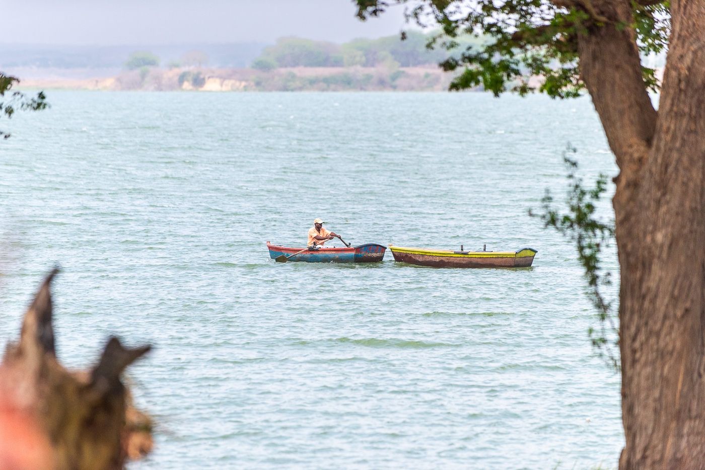 A man rowing a small boat on the Kilunda Lagoon, with a second boat alongside