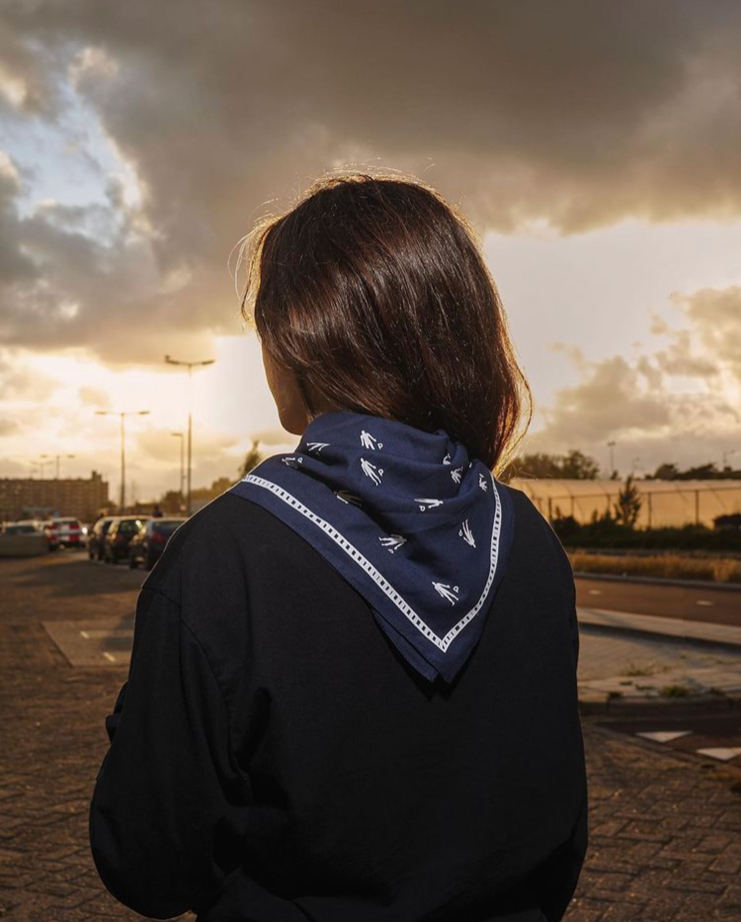 Person wearing a Pinkman bandana at sunset, seen from behind