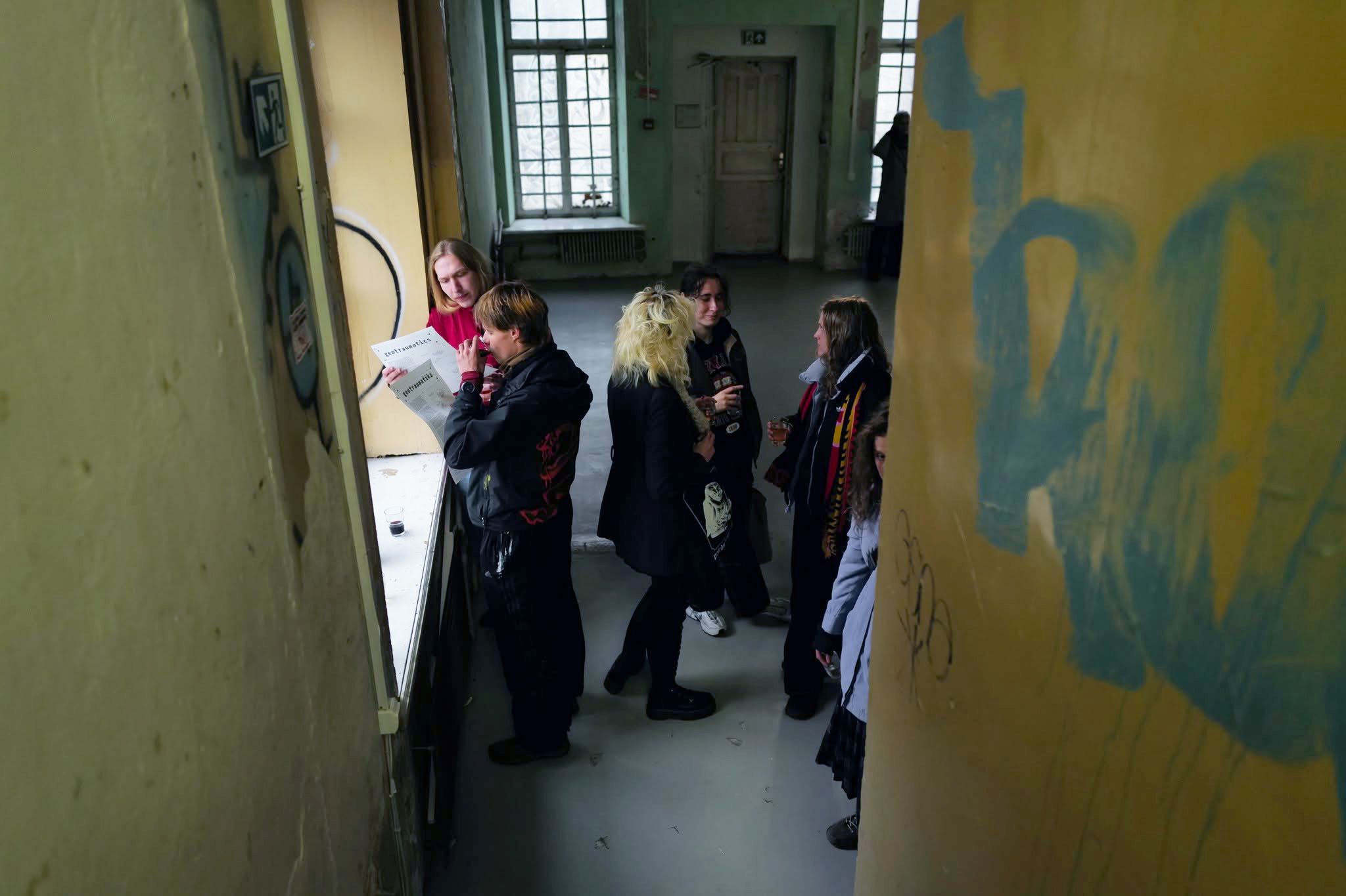 Visitors in a raw gallery corridor at the Geotraumatika opening