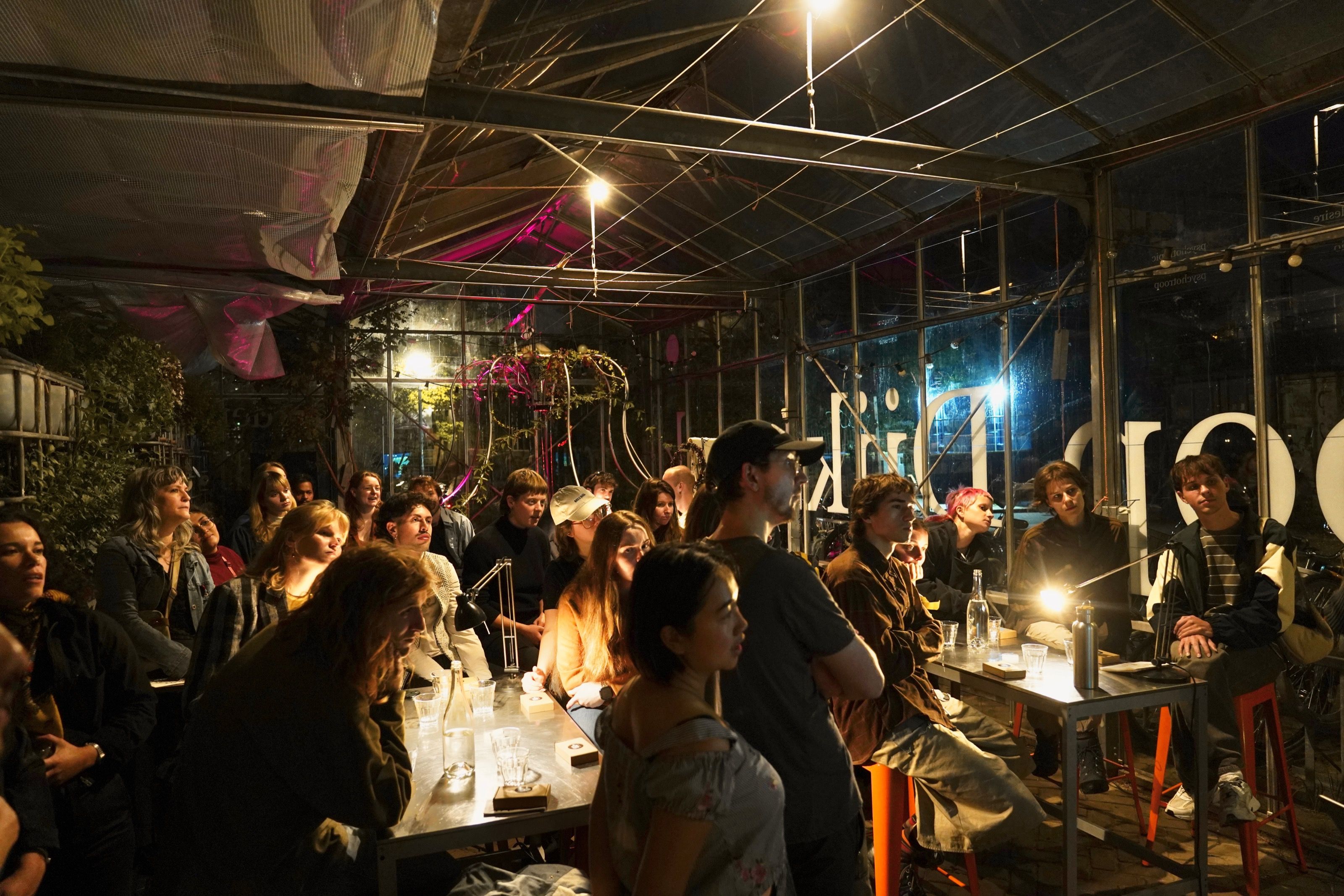 Crowded evening slime mould workshop in a greenhouse