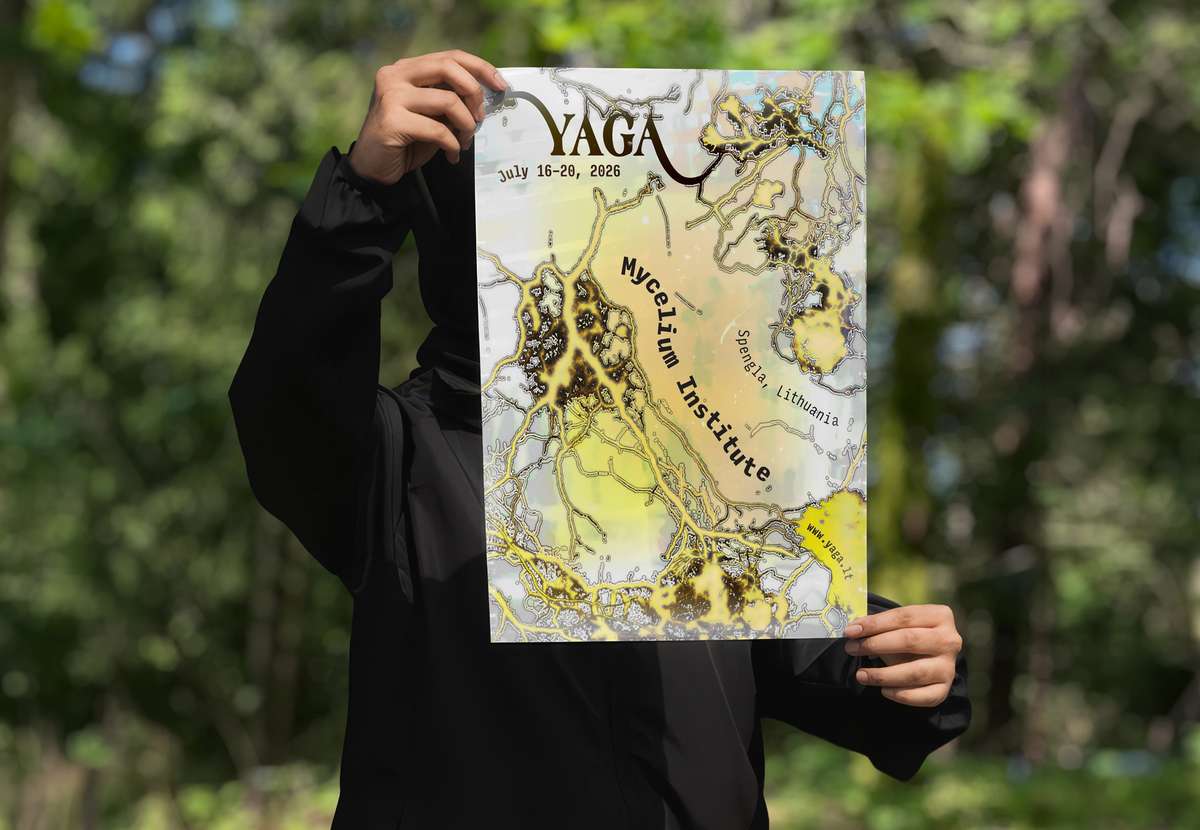 A person in a forest holding up the YAGA Gathering poster
