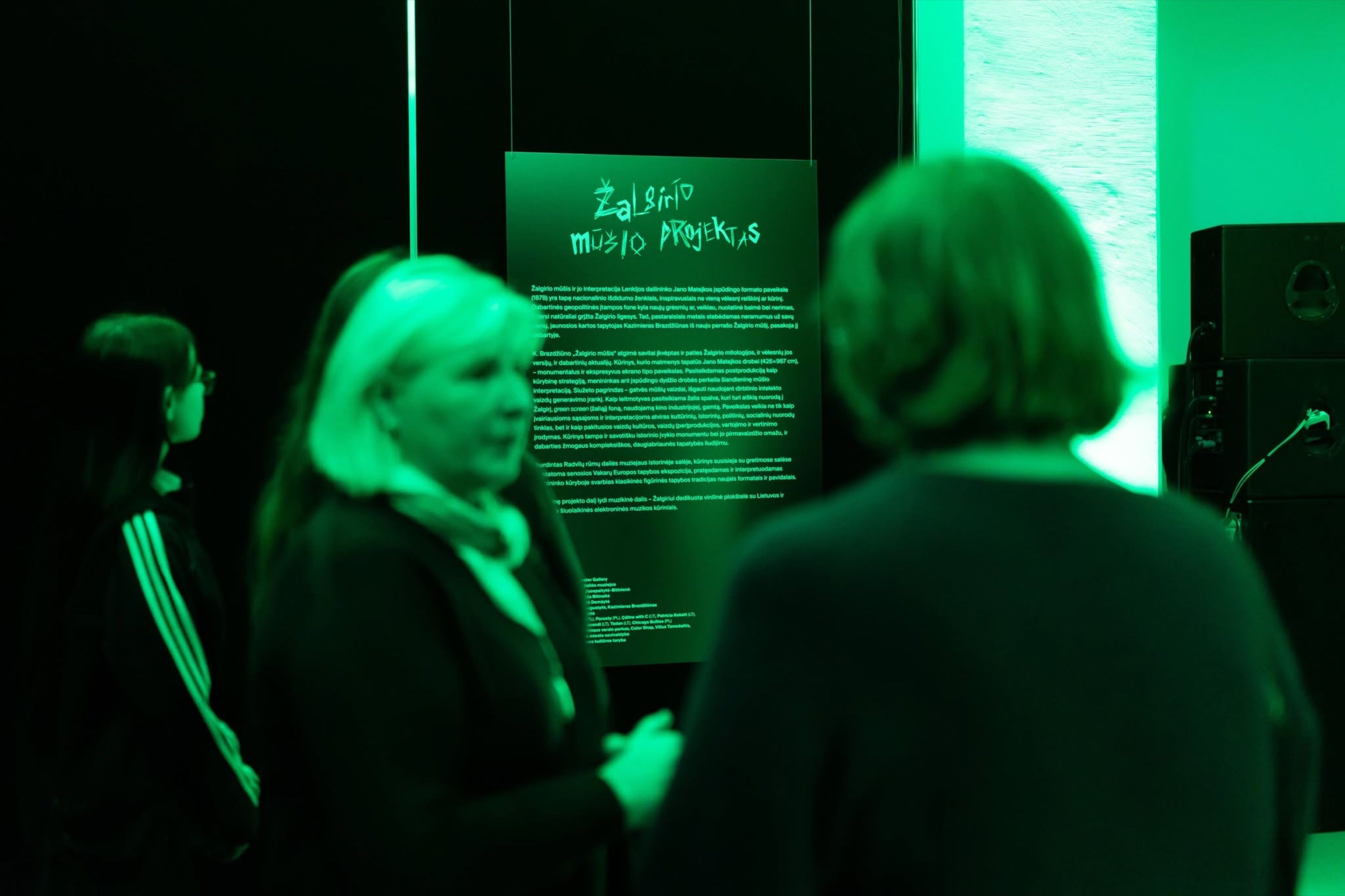 Visitors reading wall text at the Žalgiris Battle Project exhibition