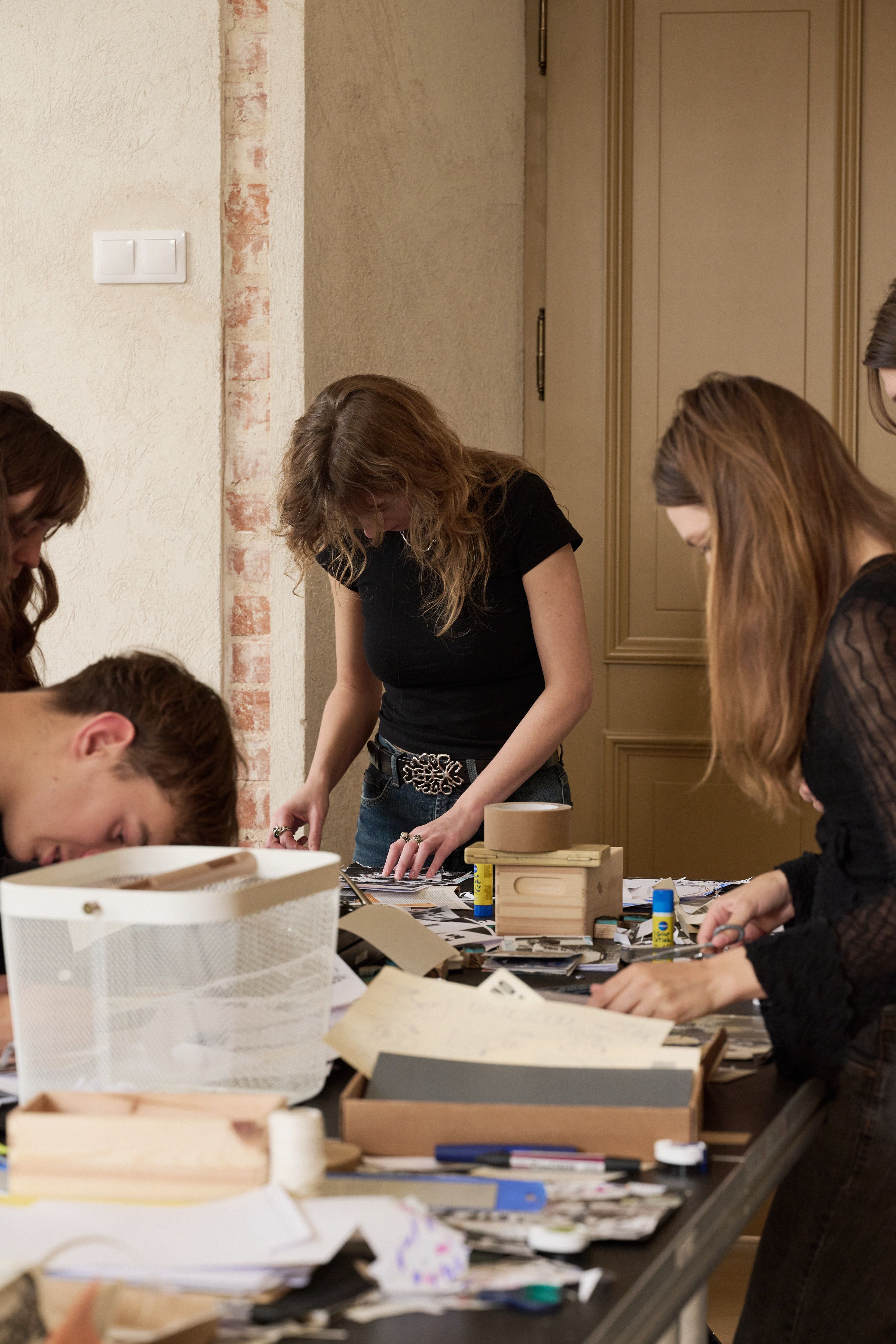 Participants laying out zine pages among boxes of material