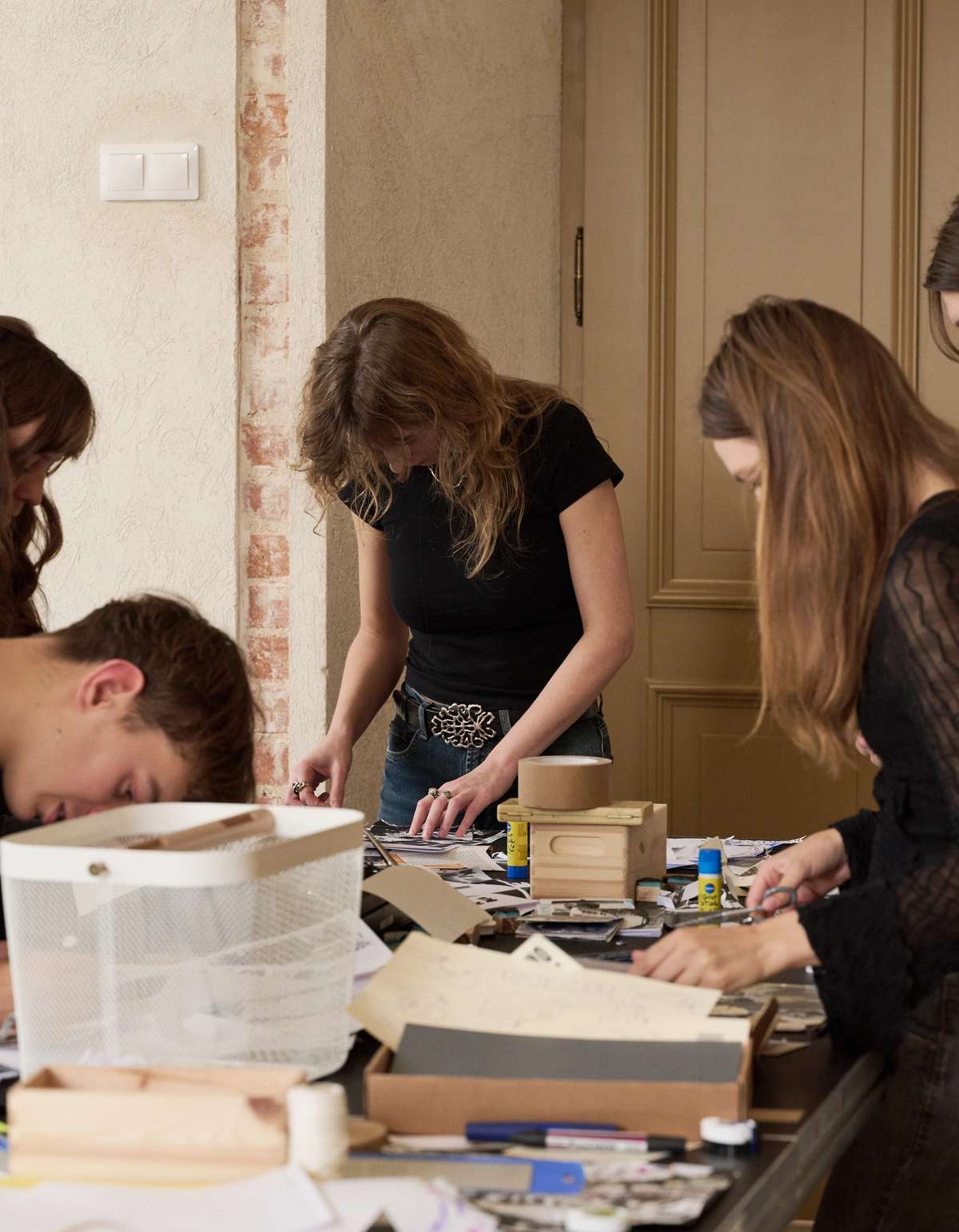 Participants laying out zine pages among boxes of material