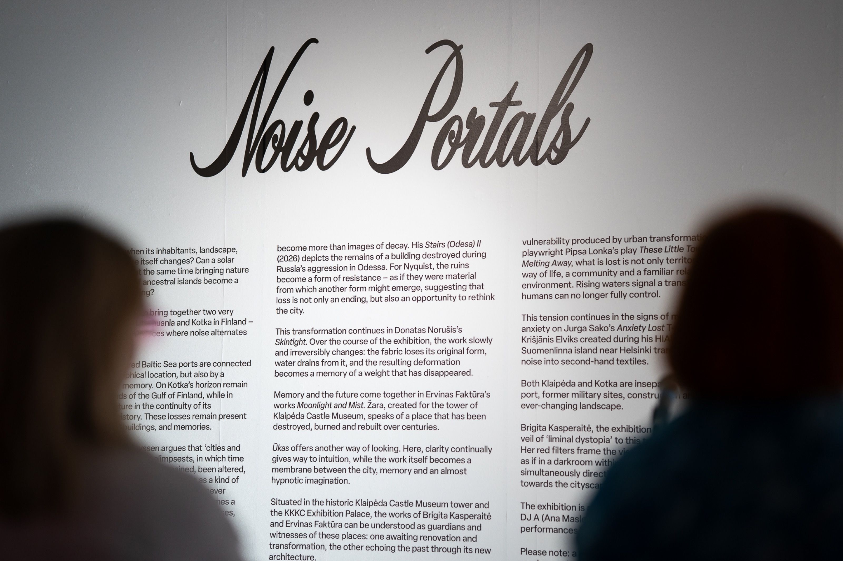 Noise Portals title wall with exhibition text, visitors in the foreground