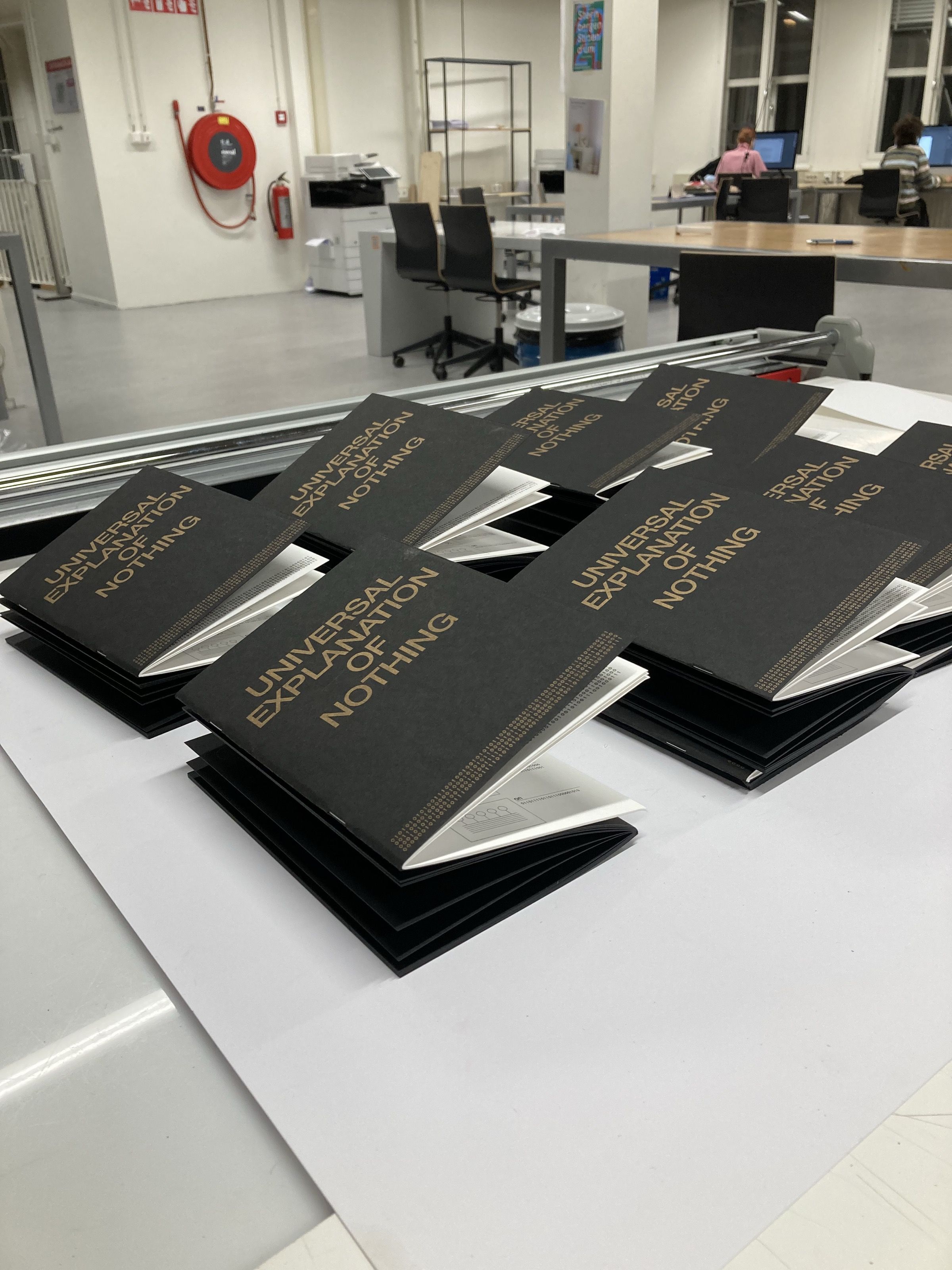 Copies of Universal Explanation of Nothing laid out on a table