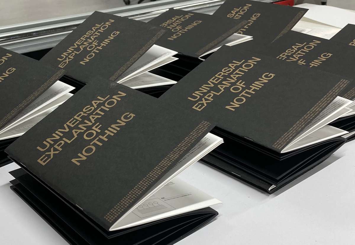 Copies of Universal Explanation of Nothing laid out on a table