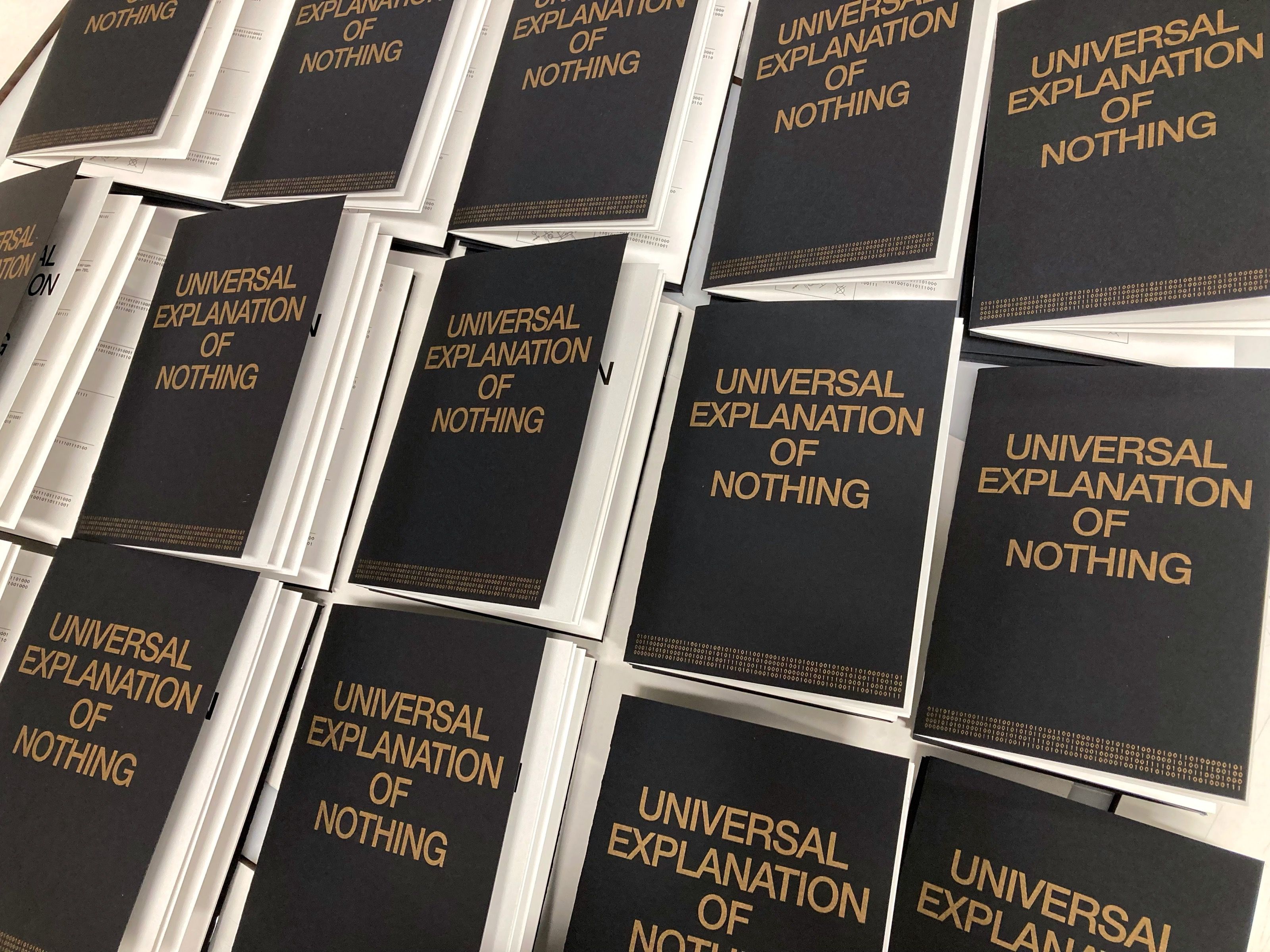 Stacks of Universal Explanation of Nothing books with gold lettering