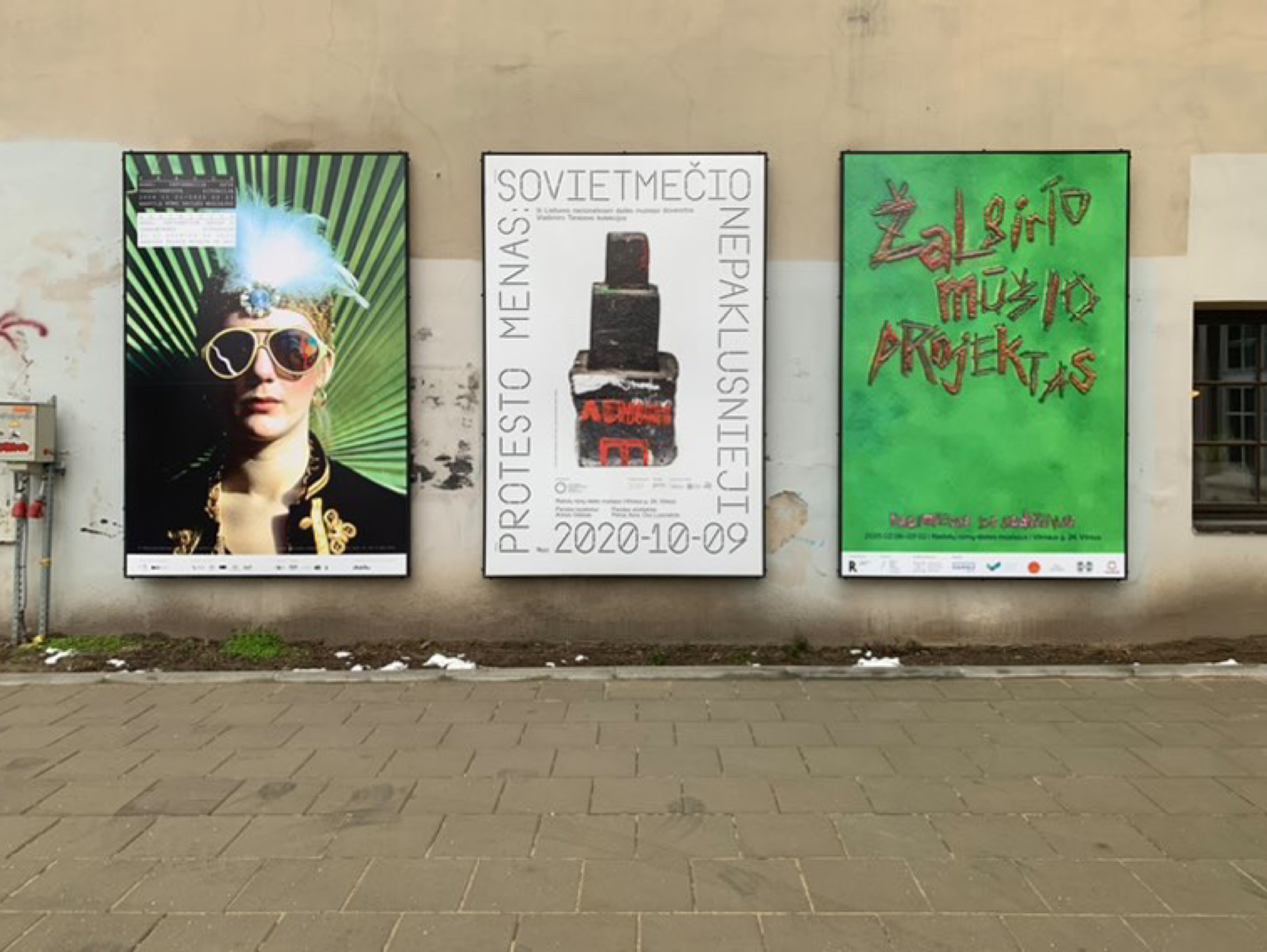 Exhibition posters including Žalgiris Battle Project pasted on a street wall