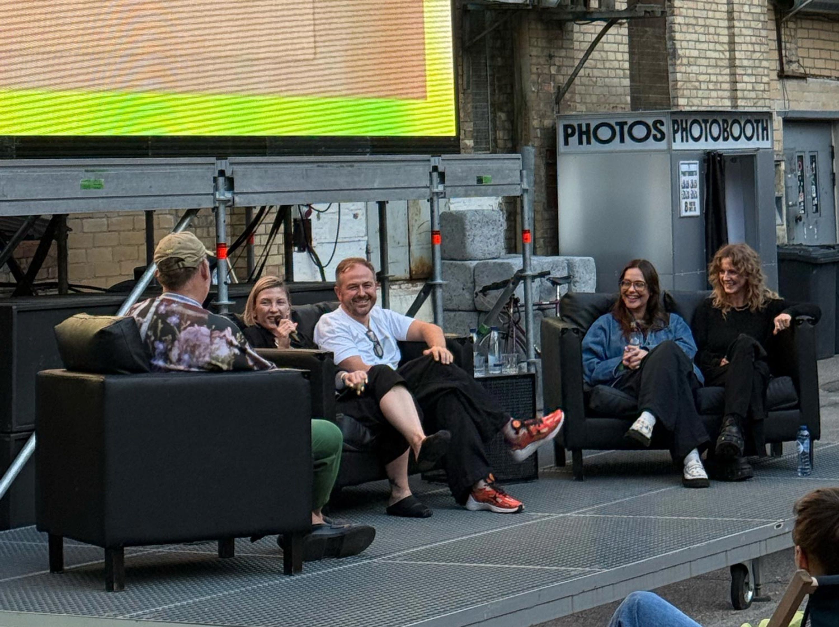Panel conversation on sofas at an outdoor festival stage