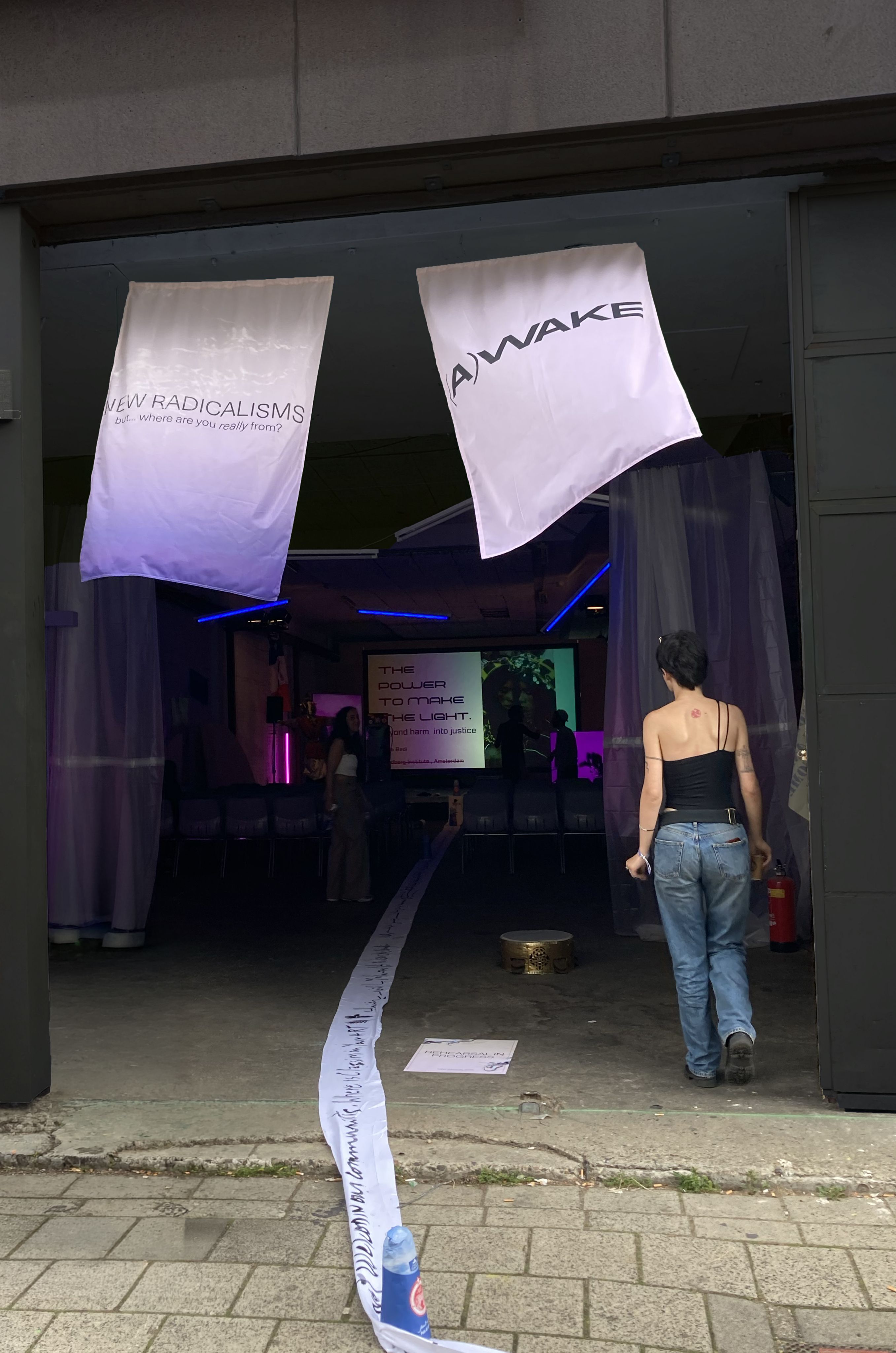 Festival entrance hung with New Radicalisms banners, a visitor walking in