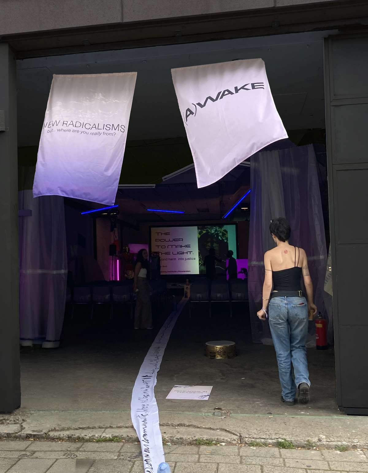 Festival entrance hung with New Radicalisms banners, a visitor walking in