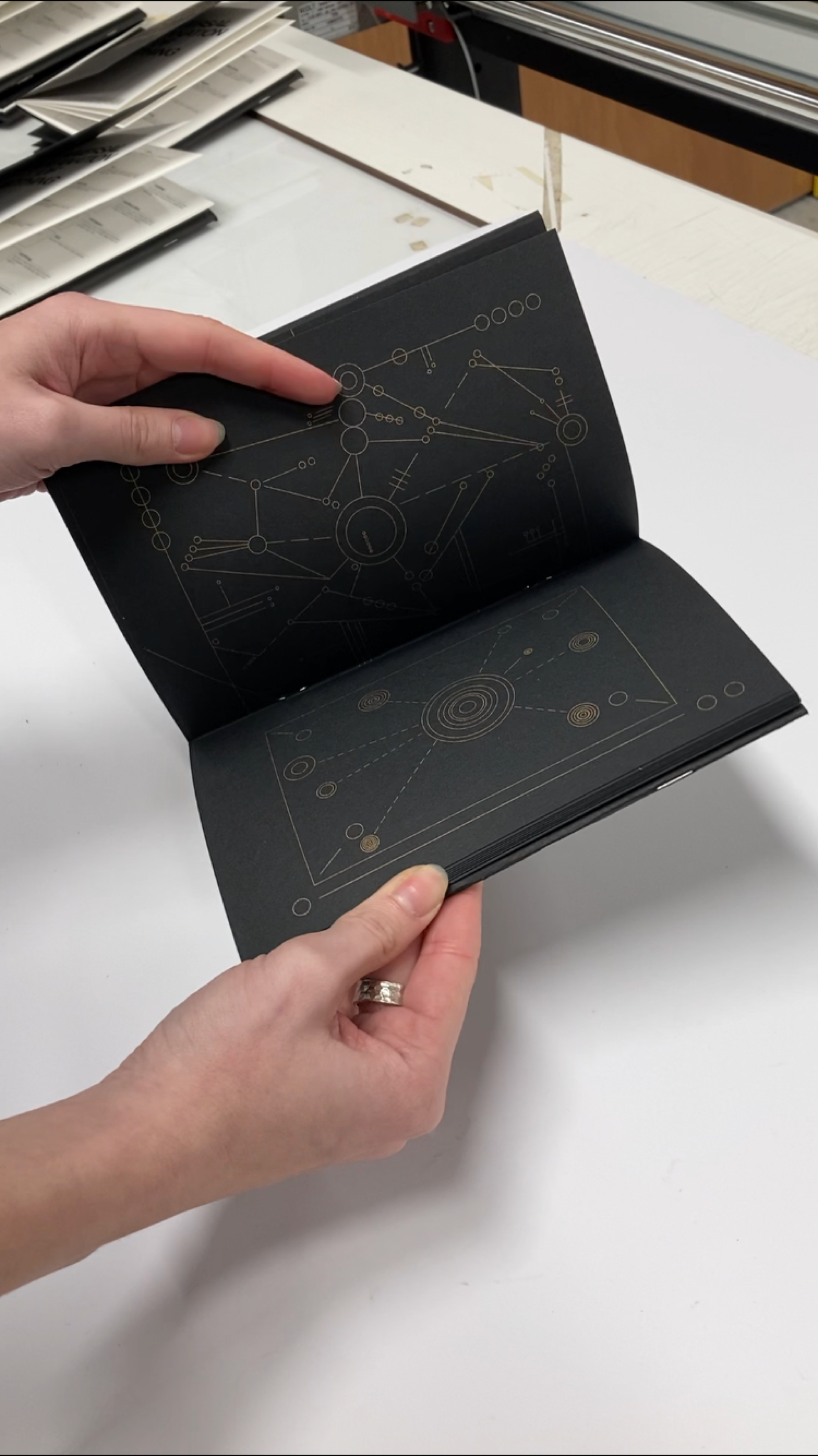 Open Universal Explanation of Nothing book with gold line drawings on black pages