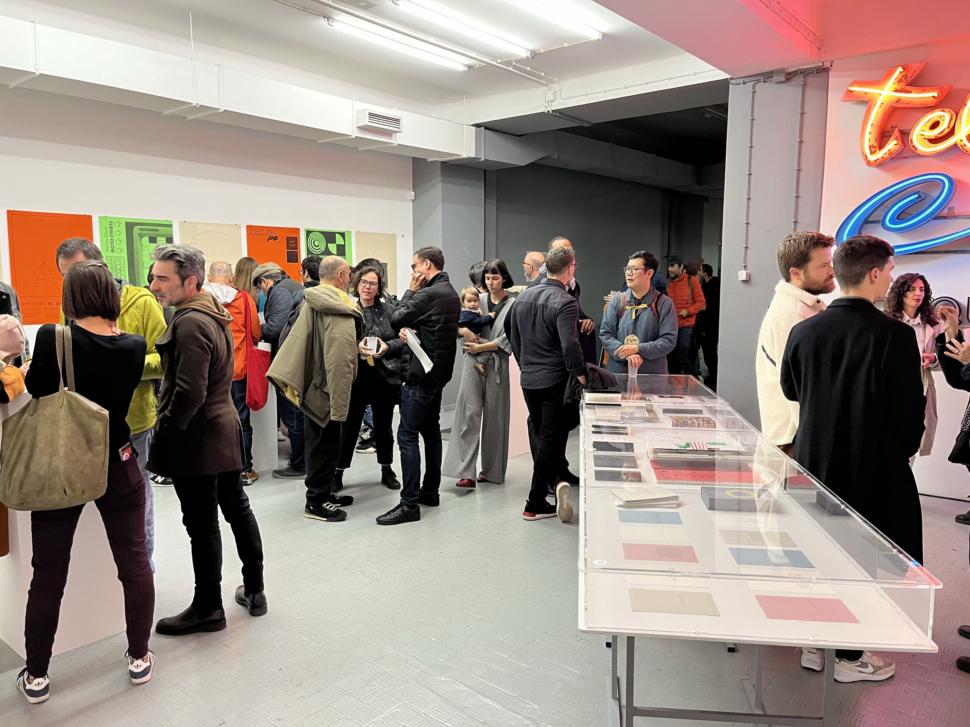Visitors at a book presentation with publications on a long display table