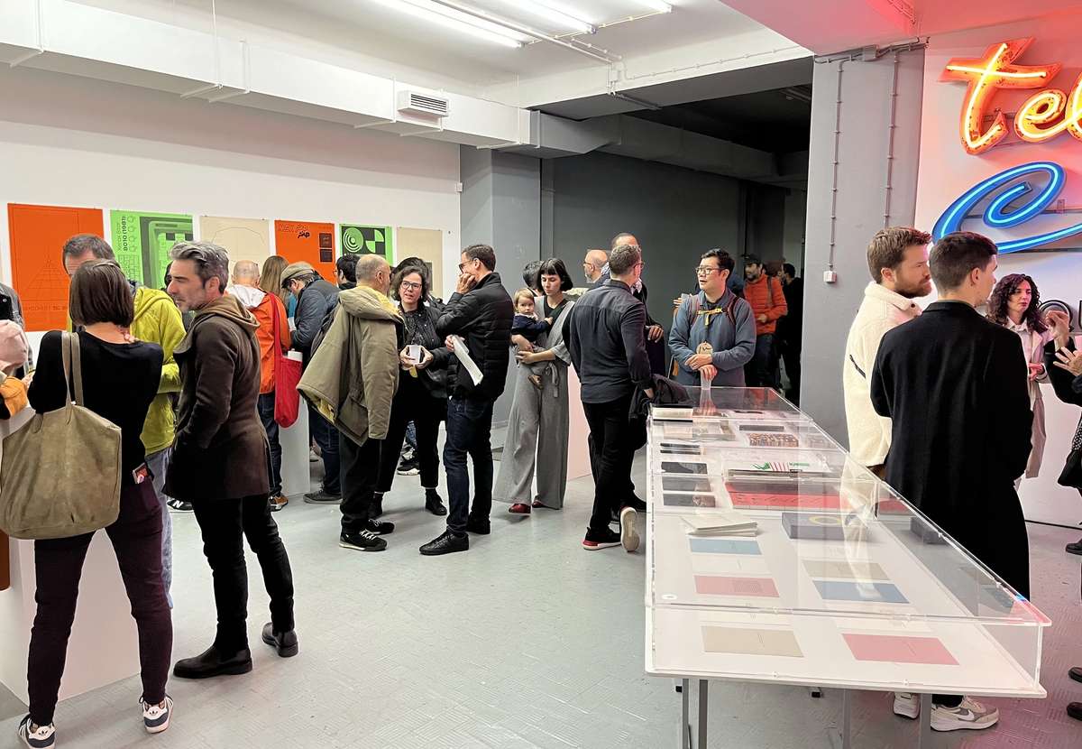 Visitors at a book presentation with publications on a long display table
