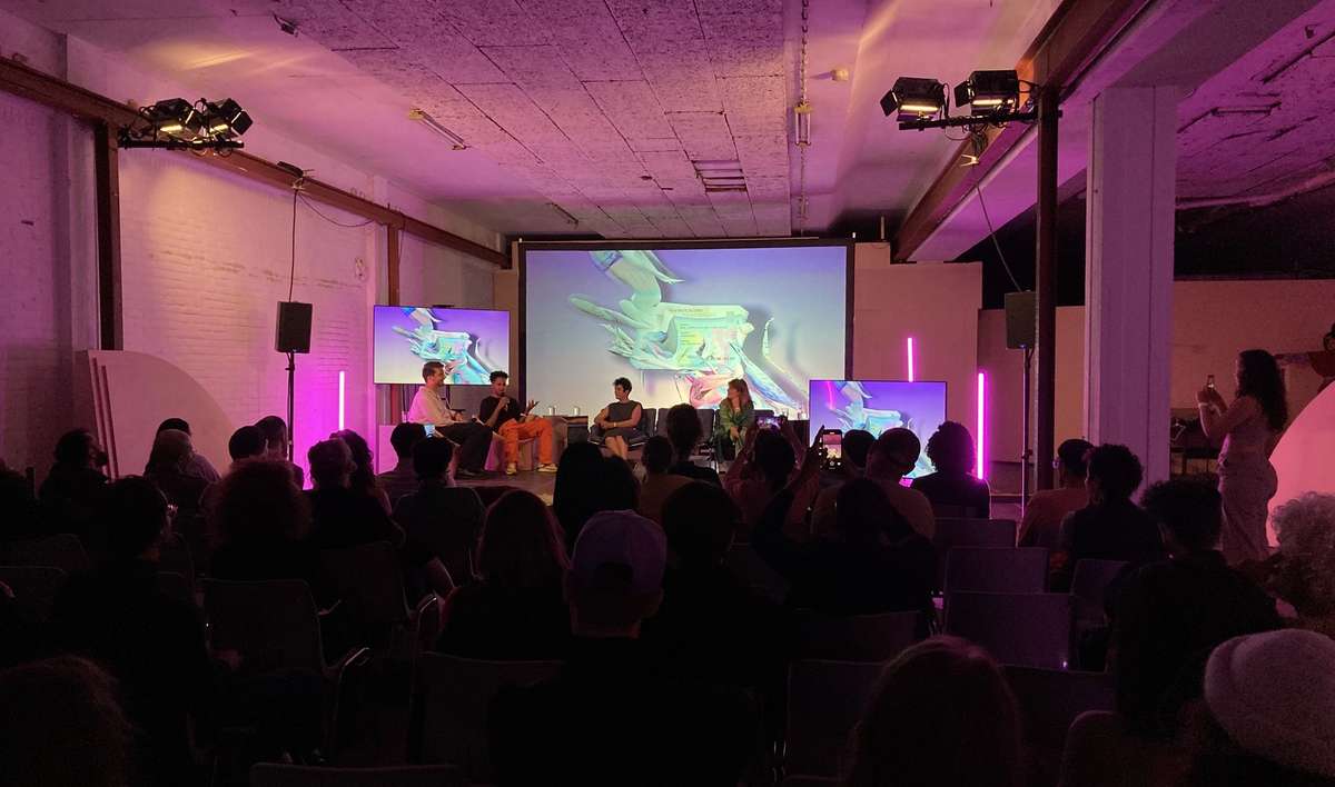 Audience at a New Radicalisms event in a pink-lit hall