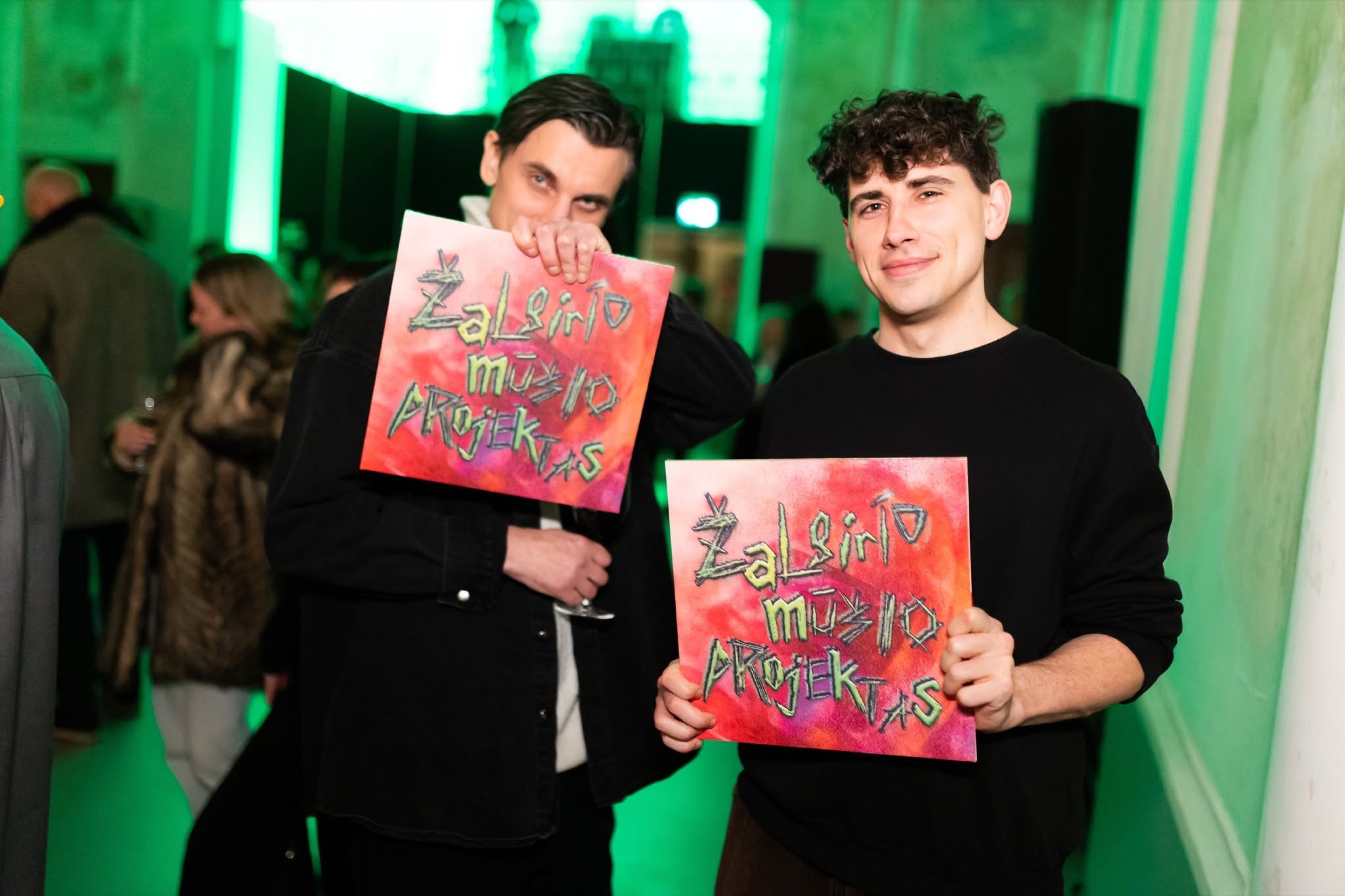 Two people holding Žalgiris Battle Project vinyl sleeves at the opening