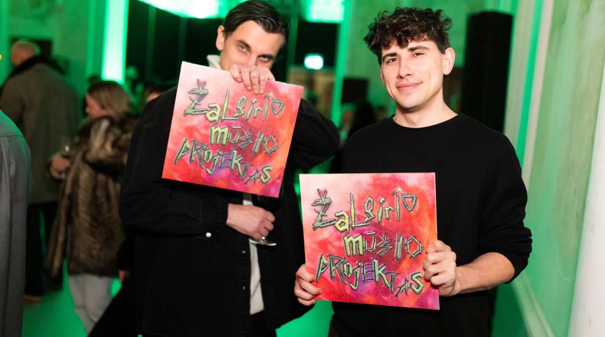 Two people holding Žalgiris Battle Project vinyl sleeves at the opening