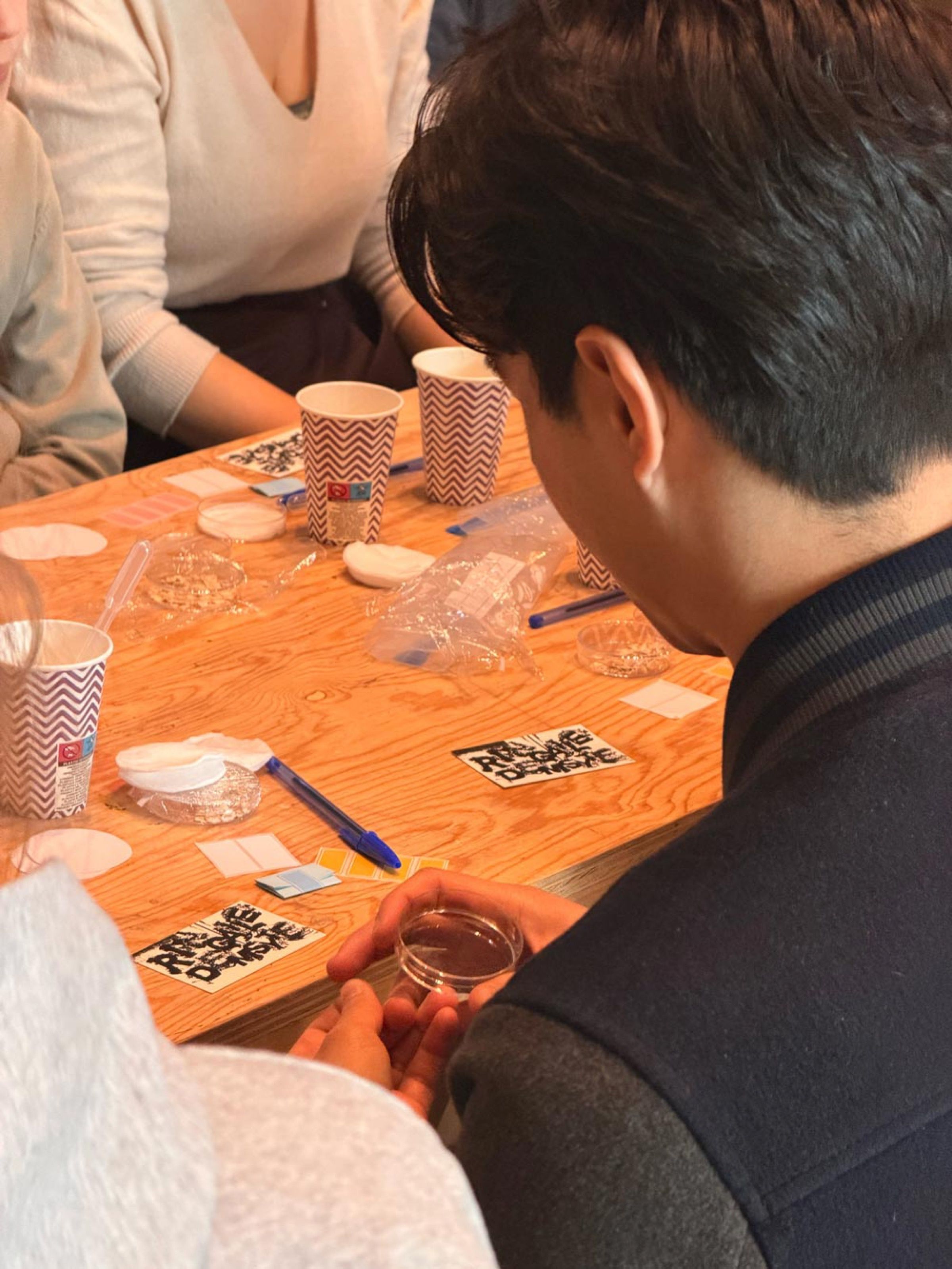 Participant holding a petri dish at a workshop table