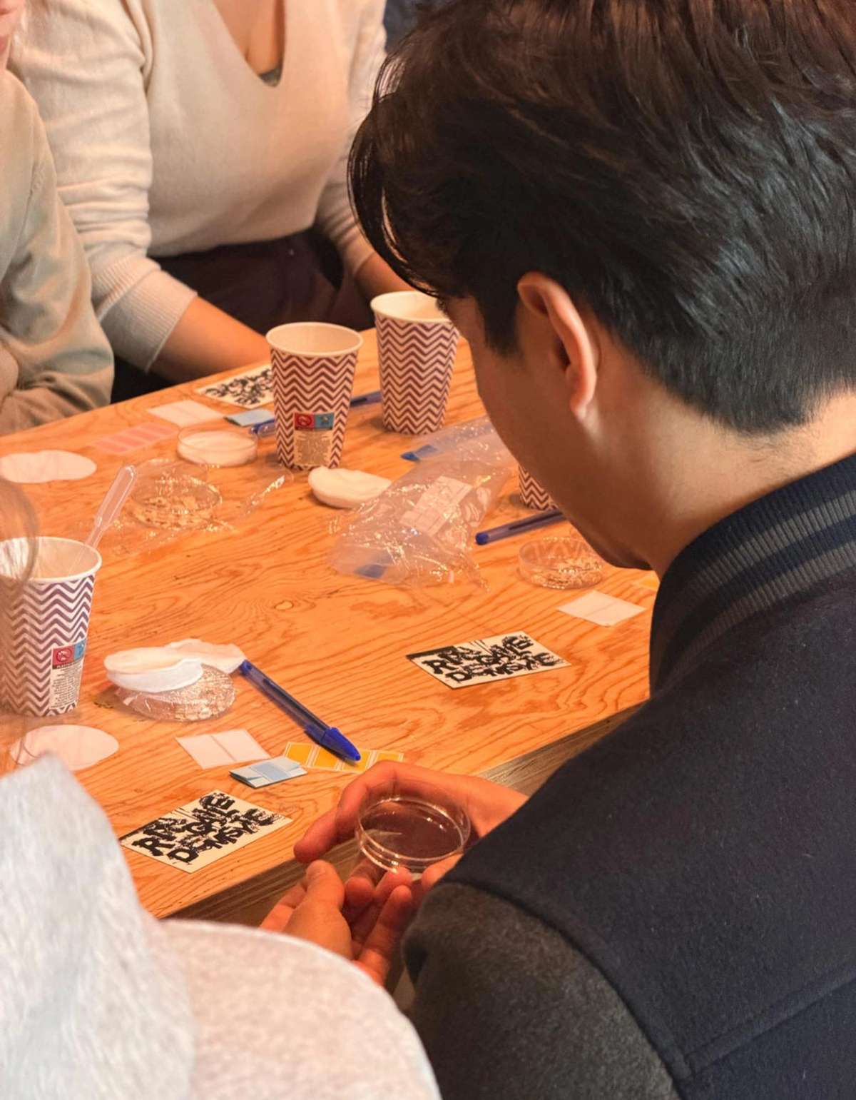Participant holding a petri dish at a workshop table