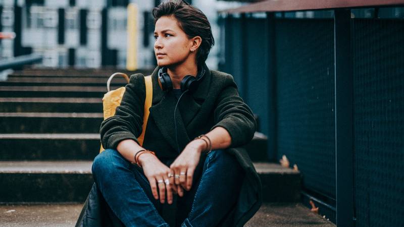 Jonge vrouw zit op een trap