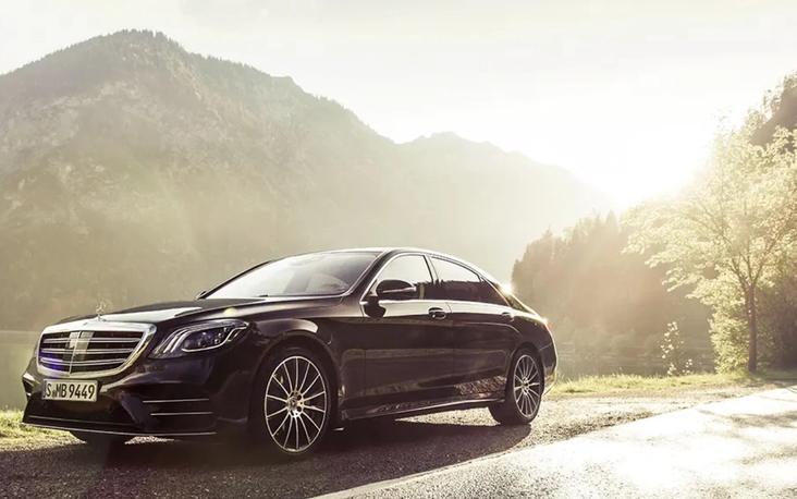 Black chauffeured sedan at the kerb
