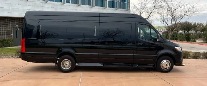 Black Mercedes Sprinter limousine van, side view, parked outside an office building