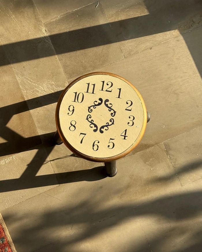 Stool with a hand-painted clock face top and gold rim