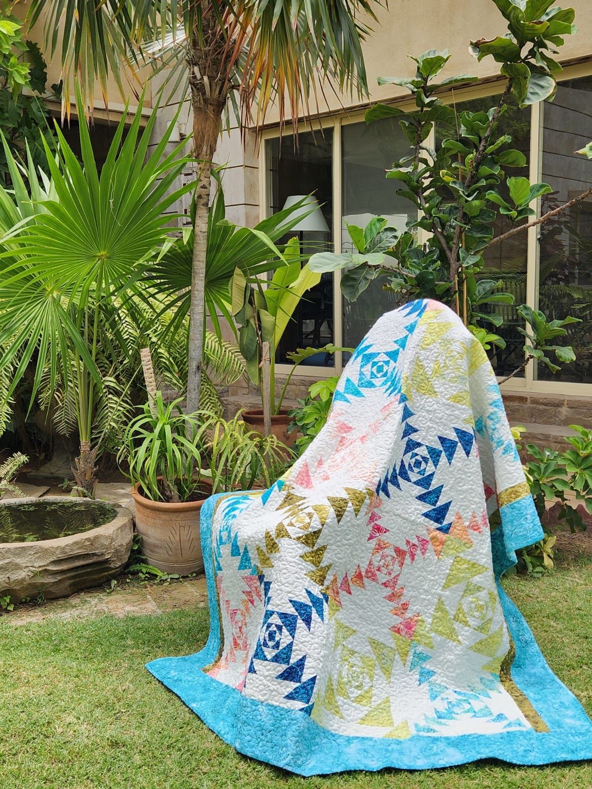 Teal flying geese throw draped over a garden chair