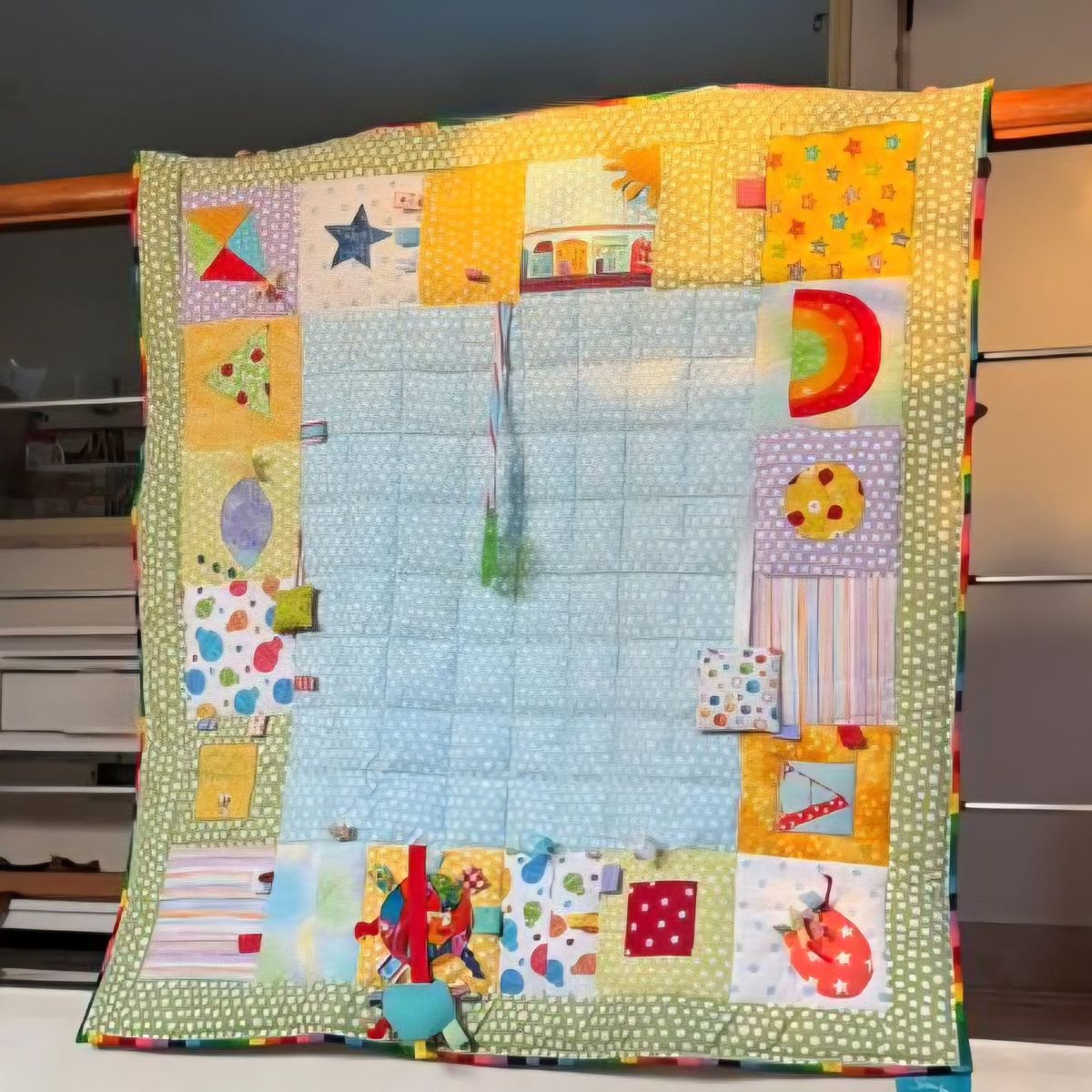 Sensory playmat hanging up, showing ribbon tags and textured patches