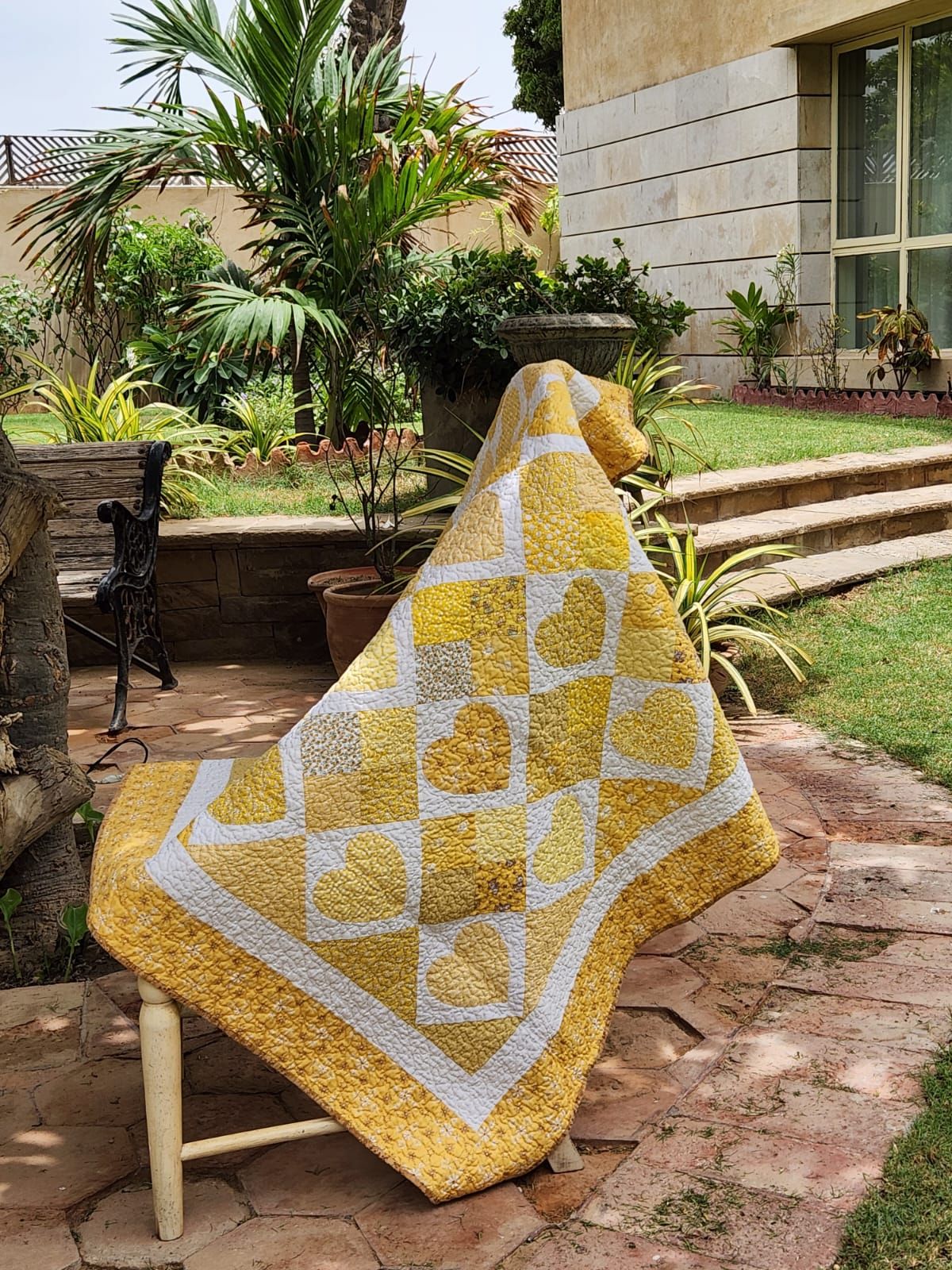 Golden hearts quilt hung against a window