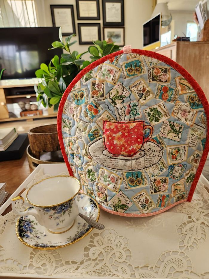 Front of a double-sided tea cosy: an appliqué floral teacup on seed-packet fabric