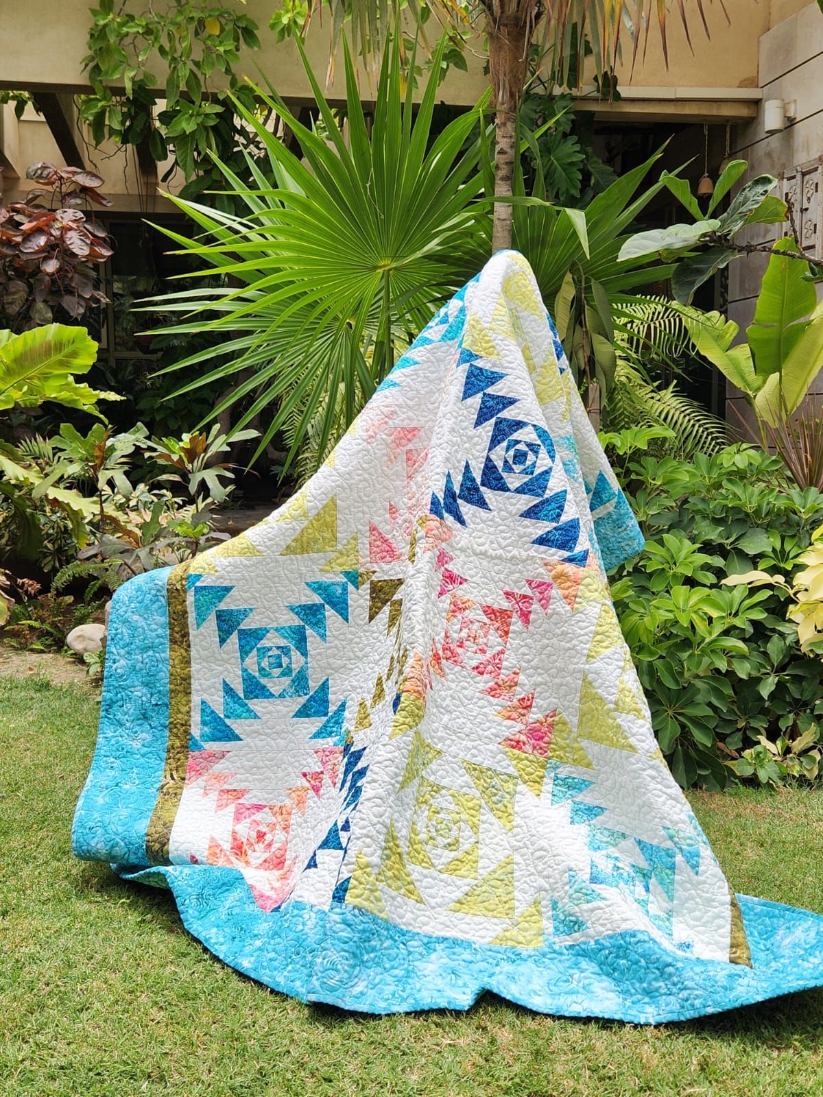 Teal flying geese throw draped over a garden chair from another angle