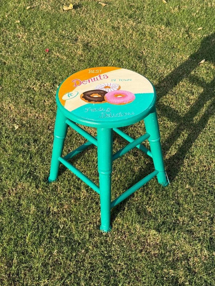 Teal stool hand-painted with a retro Best Donuts in Town sign