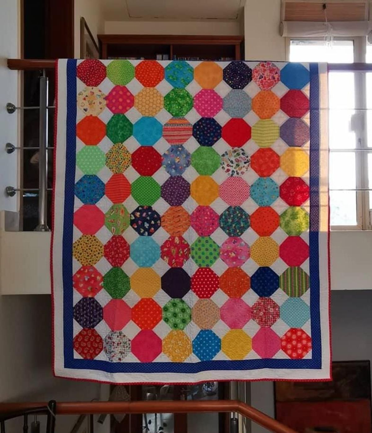 Rainbow dots quilt hung flat from another angle
