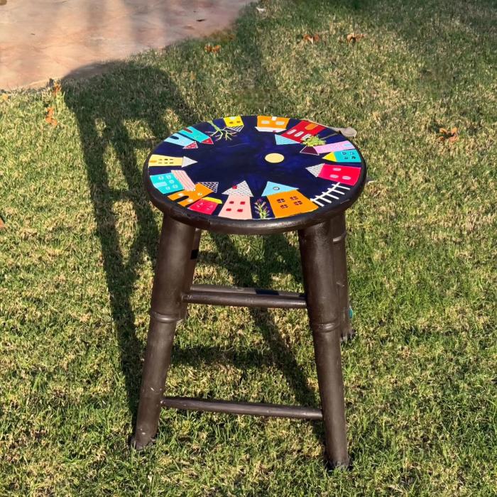 Hand-painted stool with colourful houses circling a midnight-blue top