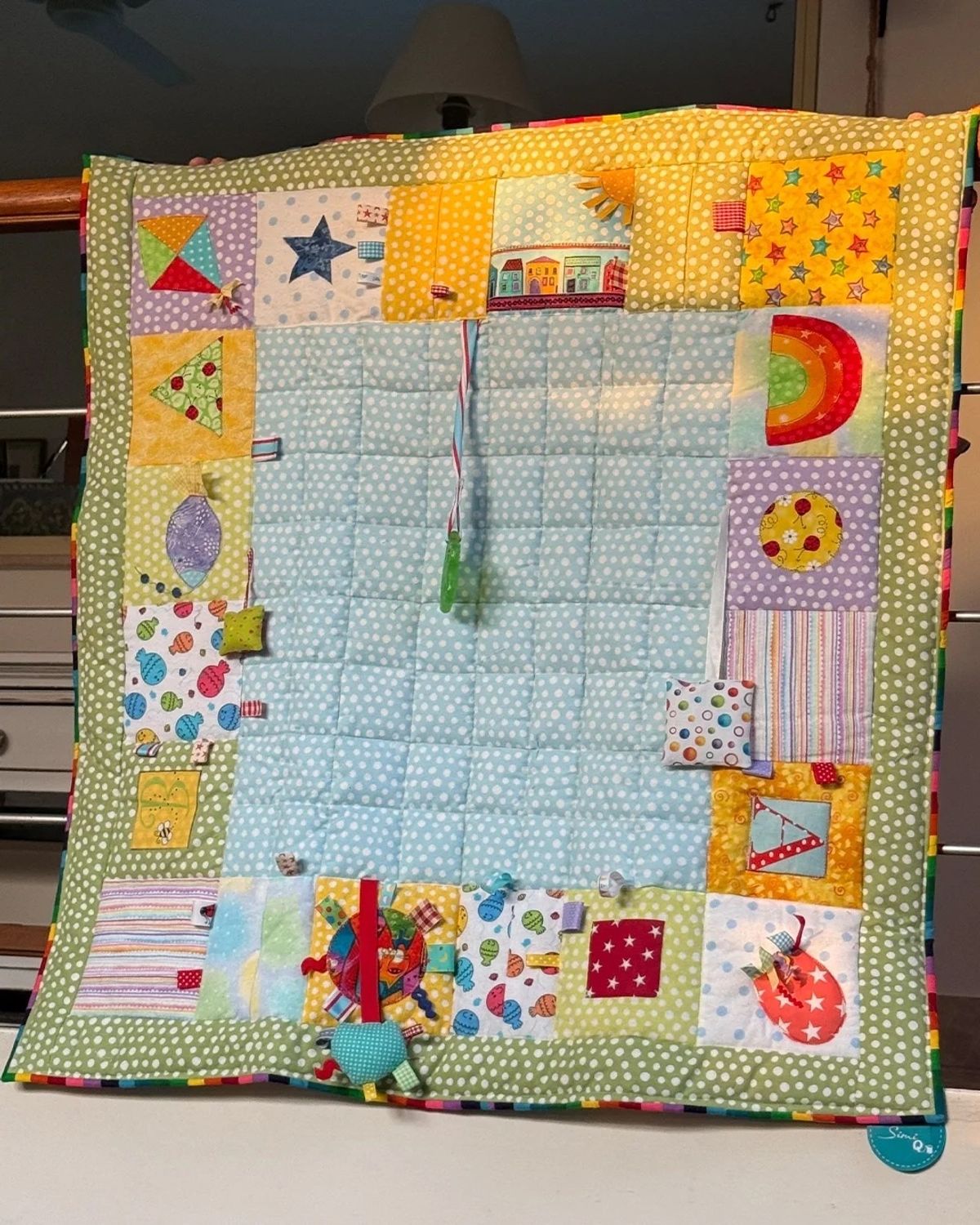 Baby sensory quilt with appliqué kite, stars and rainbow blocks