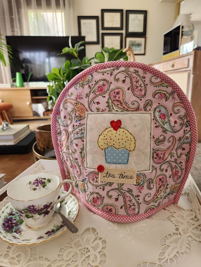 Pink paisley tea cosy with an appliqué cupcake and a hand-lettered tea time label