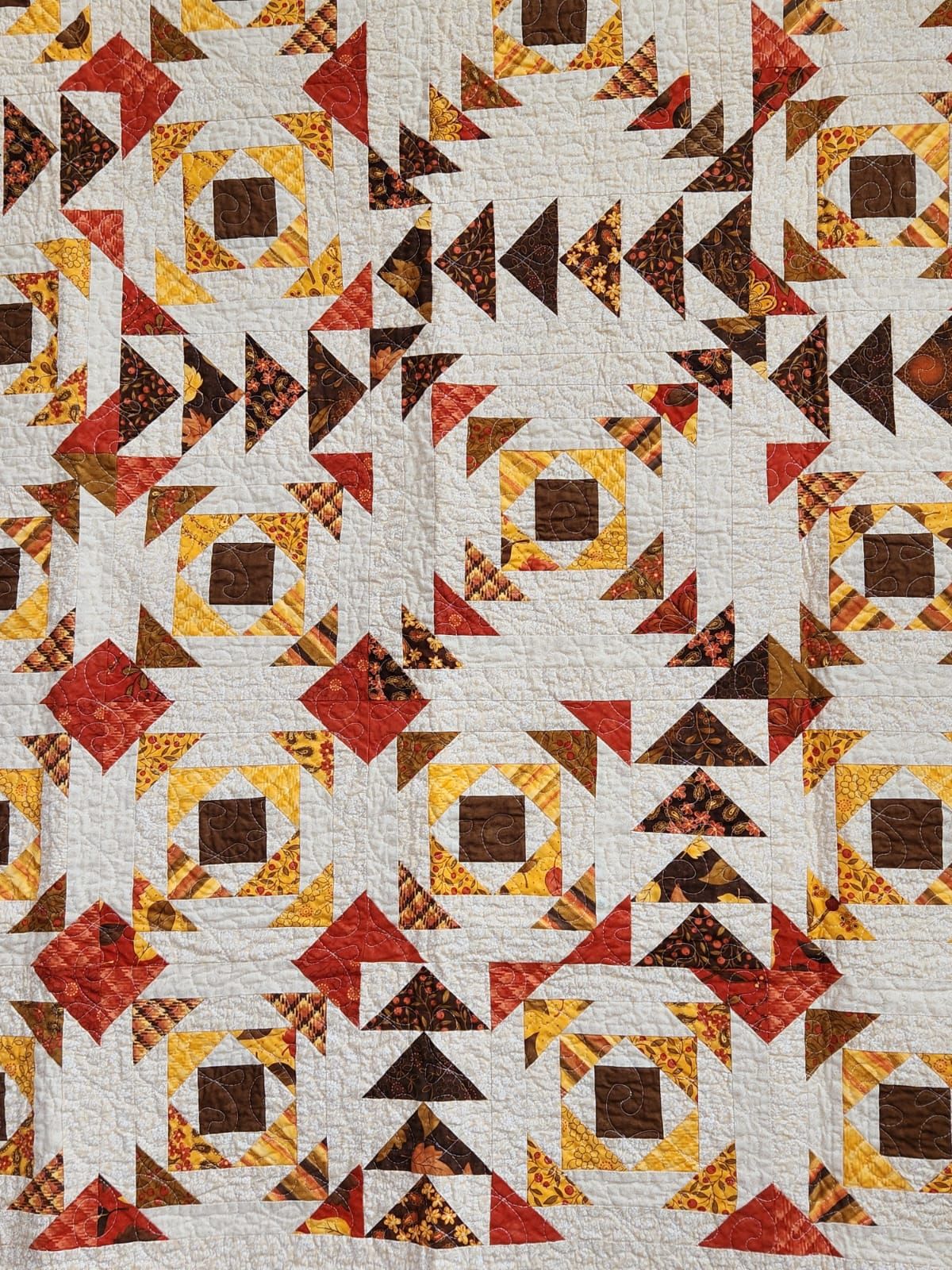 Close-up detail of the flying geese patchwork in rust, gold and chocolate
