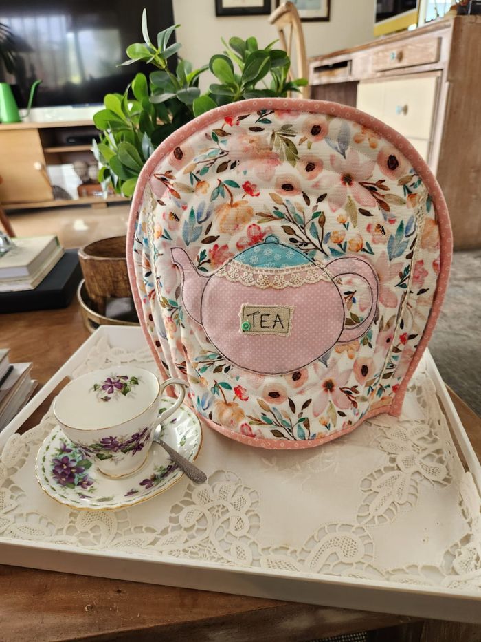 Pastel floral tea cosy with an appliqué pink teapot, lace lid and a TEA label