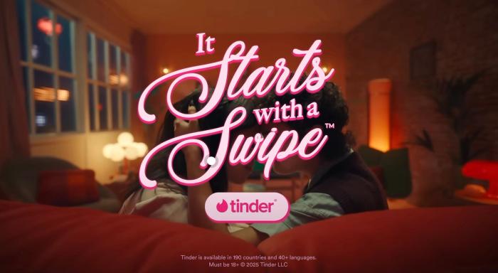 A couple young adults, representing Gen Z, laughing and interacting in a genuine, unposed manner, with the Tinder logo subtly placed. This photo is one of the teaser marketing examples from their rebranding campaign.