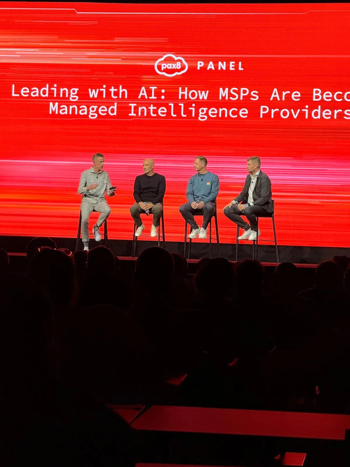 The panel Leading with AI: How MSPs Are Becoming Managed Intelligence Providers, four men on stools on the Pax8 stage