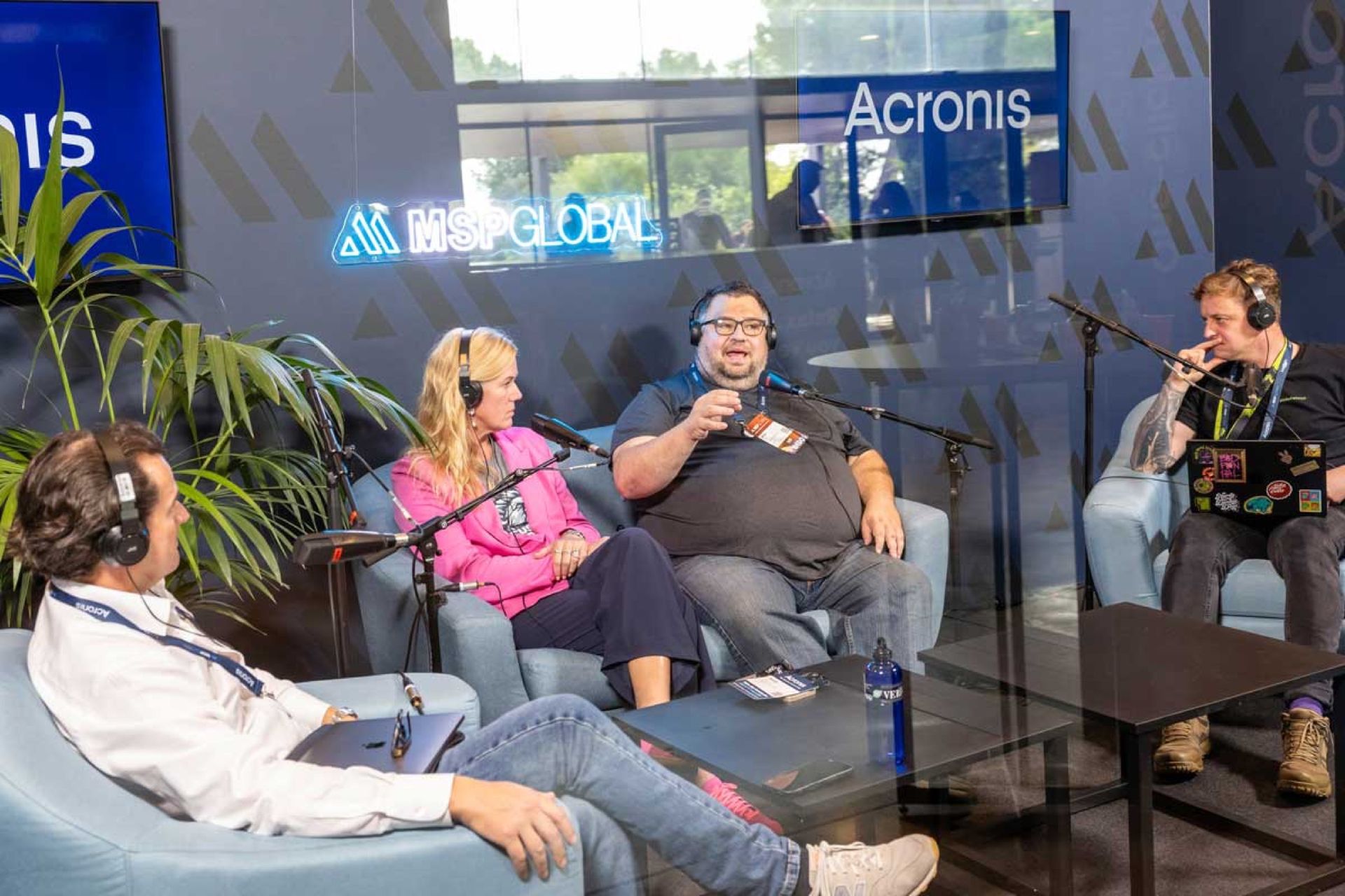 De podcaststudio op MSP Global 2025, vier mensen met koptelefoons aan tafel