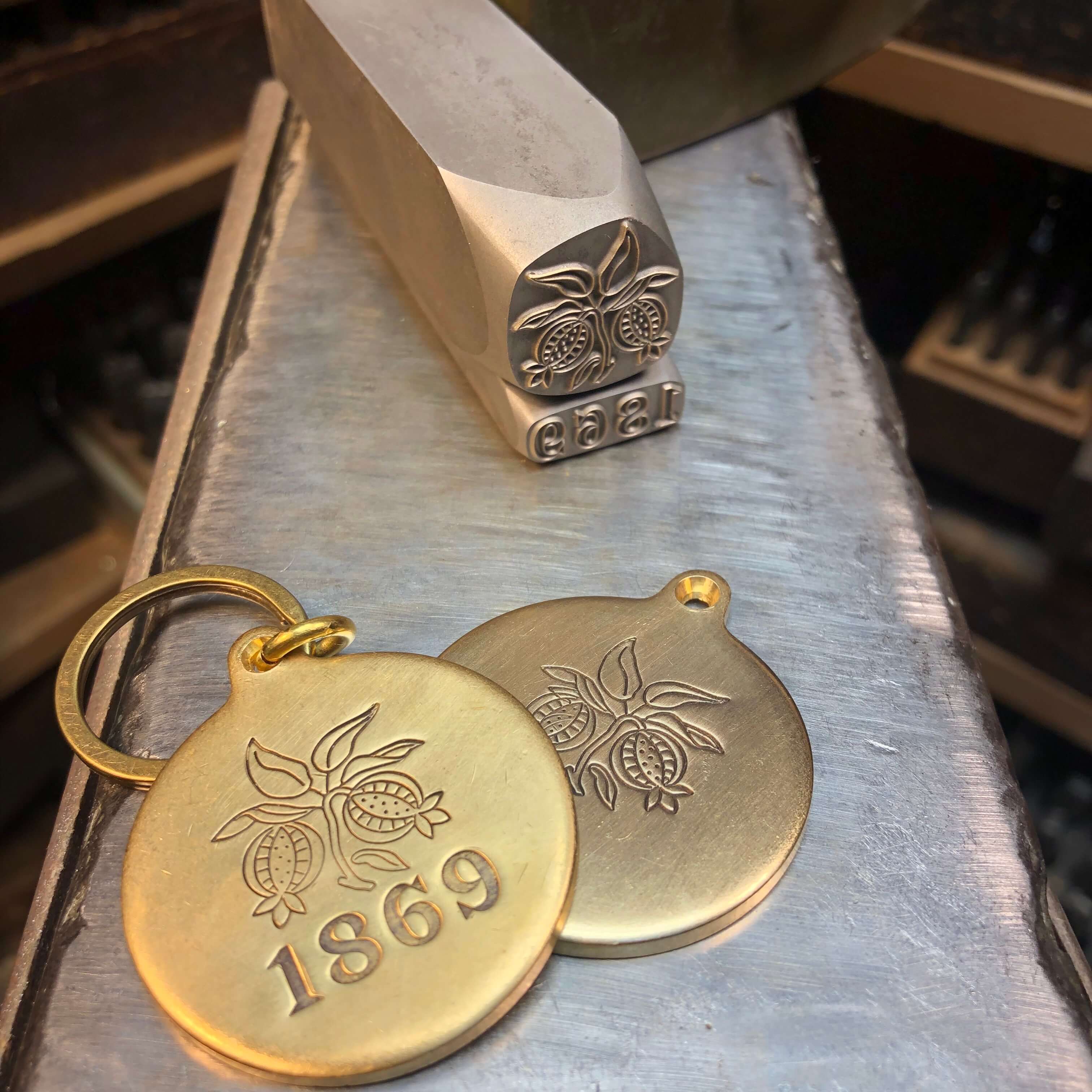 Custom brass key tags for MacArthur Place Hotel & Spa in Sonoma, California, featuring an illustrated pomegranate motif and the property’s historic 1869 founding date. Love & War developed the brand strategy, visual identity and guest experience for MacArthur Place, extending the Sonoma hotel brand into custom-designed guest materials, amenities and physical details inspired by the property’s gardens, history and natural Wine Country setting.