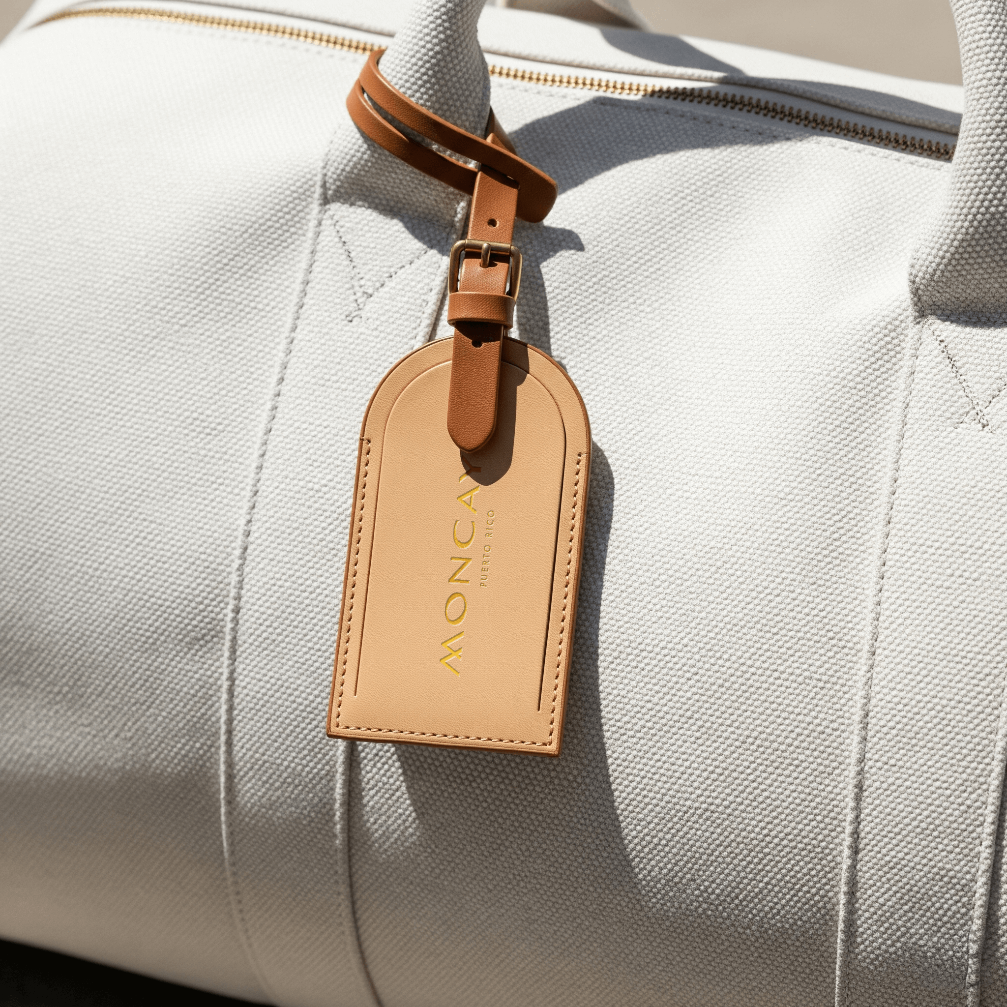 Moncayo branded leather luggage tag attached to a travel bag, showcasing the luxury destination's visual identity developed by Love & War.