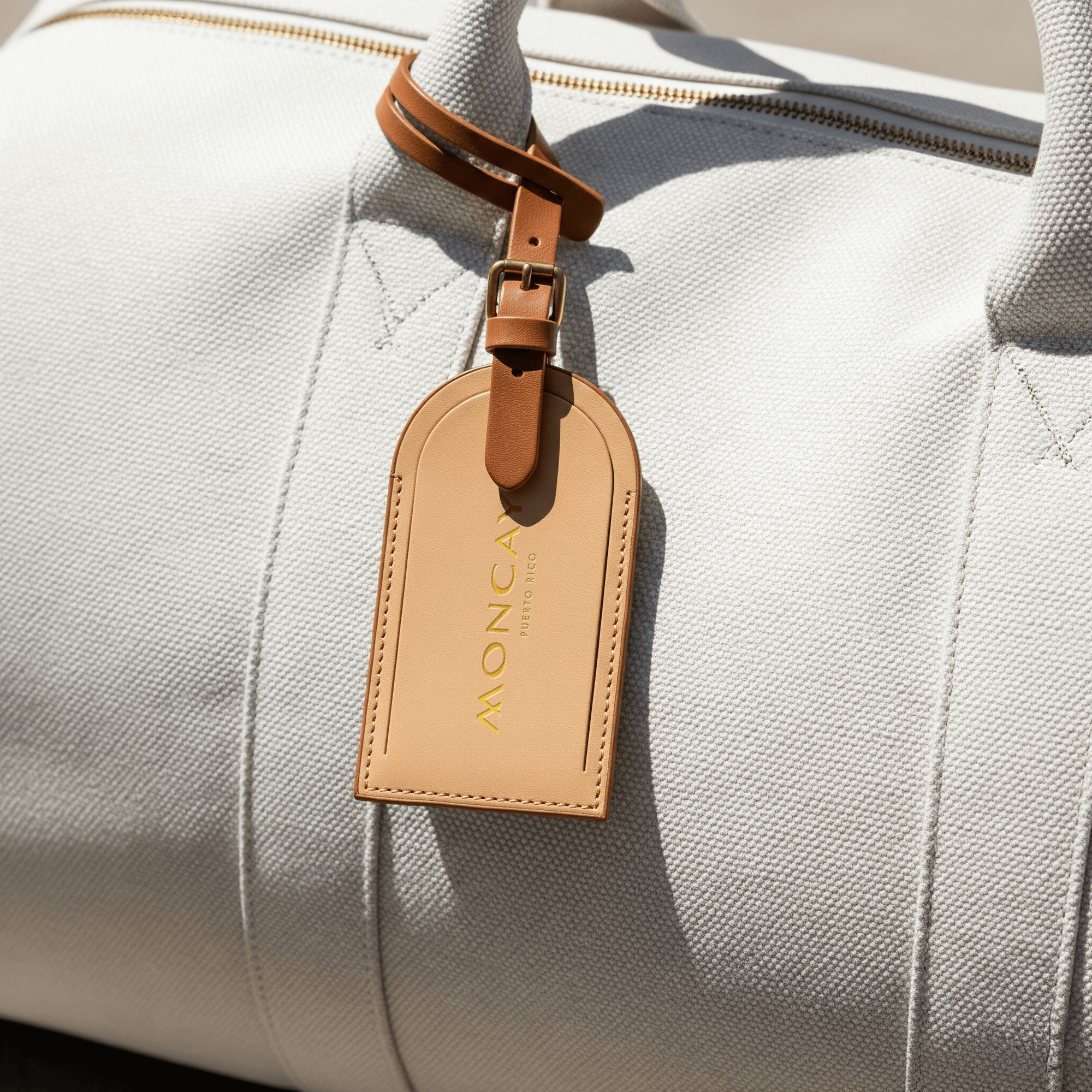 Moncayo branded leather luggage tag attached to a travel bag, showcasing the luxury destination's visual identity developed by Love & War.
