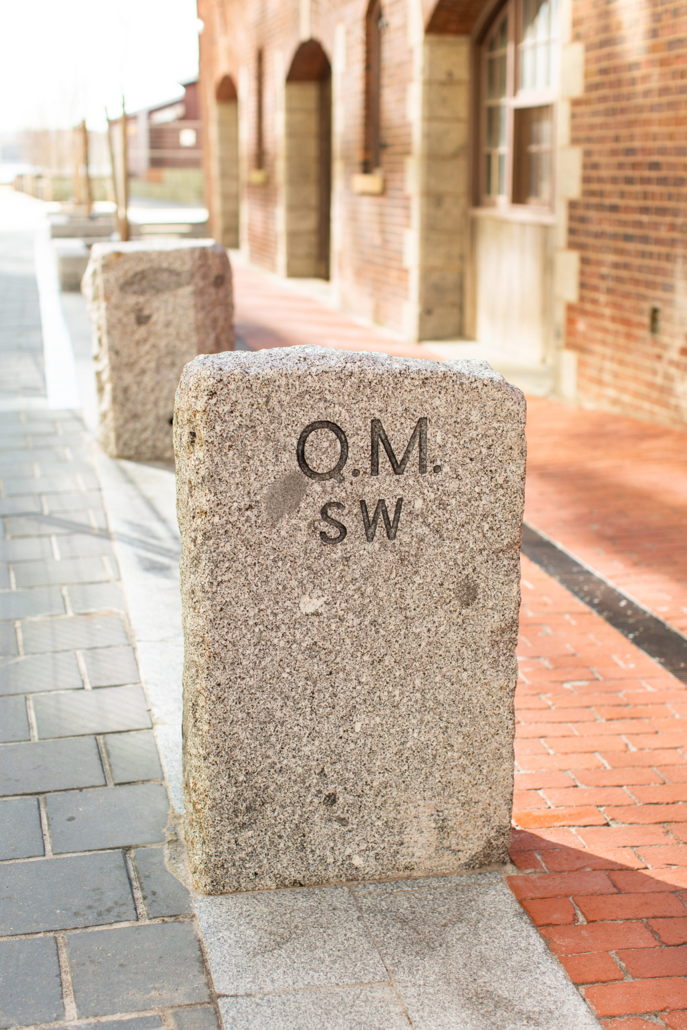 Granite wayfinding marker within Queen's Marque, Halifax's landmark waterfront district. Alongside creating the brand strategy, naming, and visual identity for Muir Halifax, Love & War developed the branding and positioning for Queen's Marque, establishing a cohesive identity that connects the district, its architecture, public spaces, and hospitality experiences.