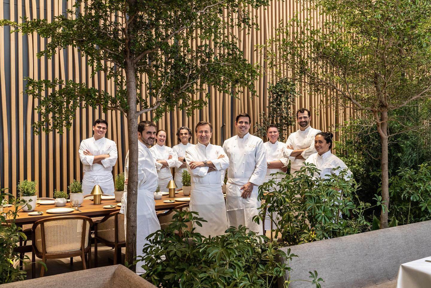 Daniel Boulud with the Le Pavillon culinary team inside the restaurant’s lush garden dining room at One Vanderbilt.