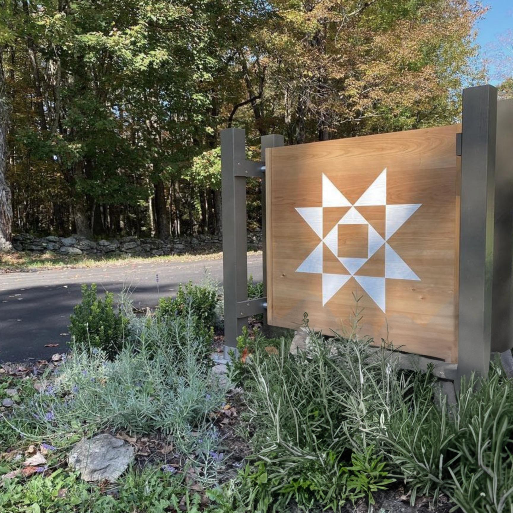 Hemlock Neversink entrance sign featuring the custom brand mark developed by Love & War for the Catskills wellness retreat.