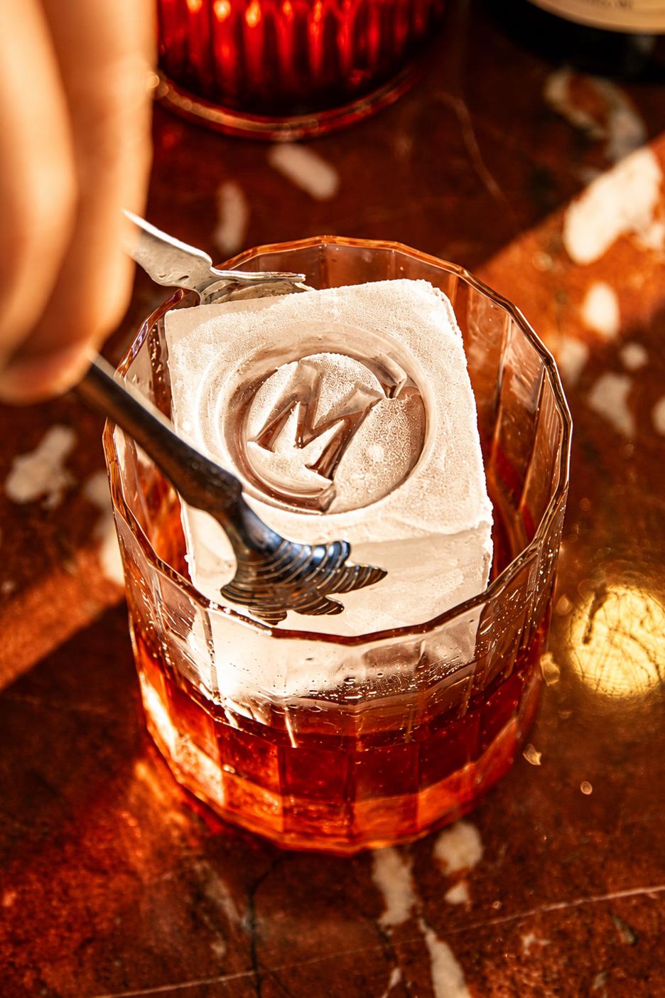 Carne Mare cocktail served over a monogrammed ice cube, reflecting the restaurant’s detailed food and beverage presentation.